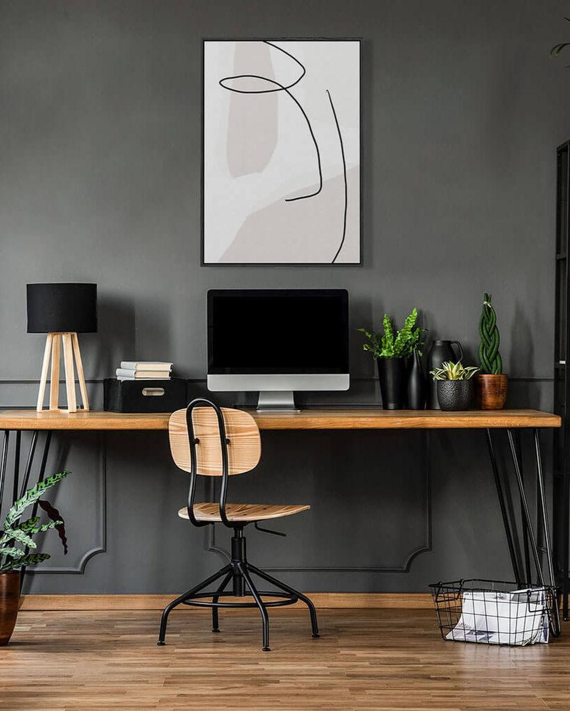 Modern home office with a wooden desk, chair, and decorative elements.
