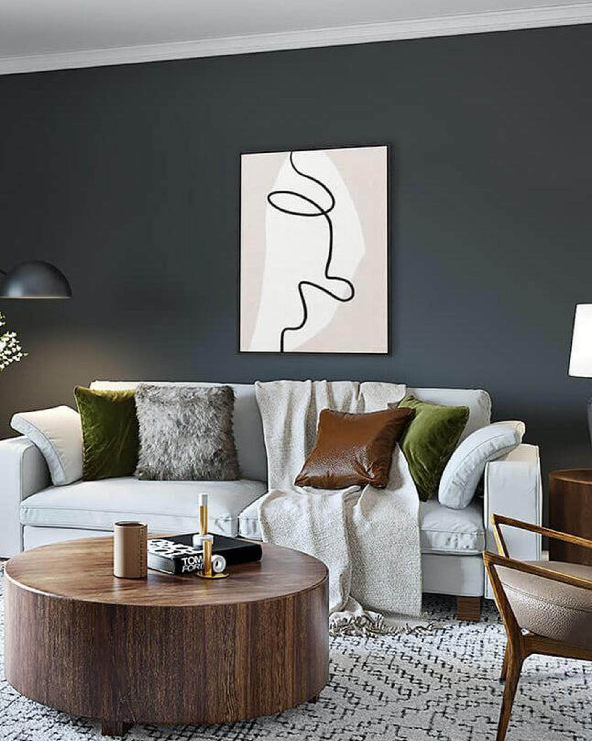 Modern living room with a gray sofa, wooden coffee table, and abstract art on the wall.