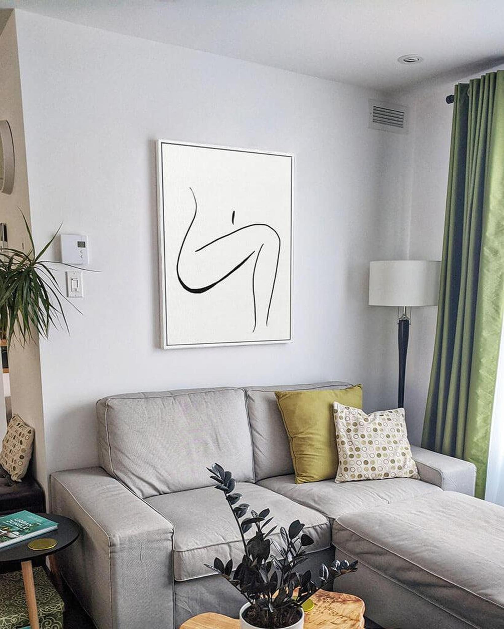 Modern living room with a gray sectional sofa, abstract art, and decorative pillows.