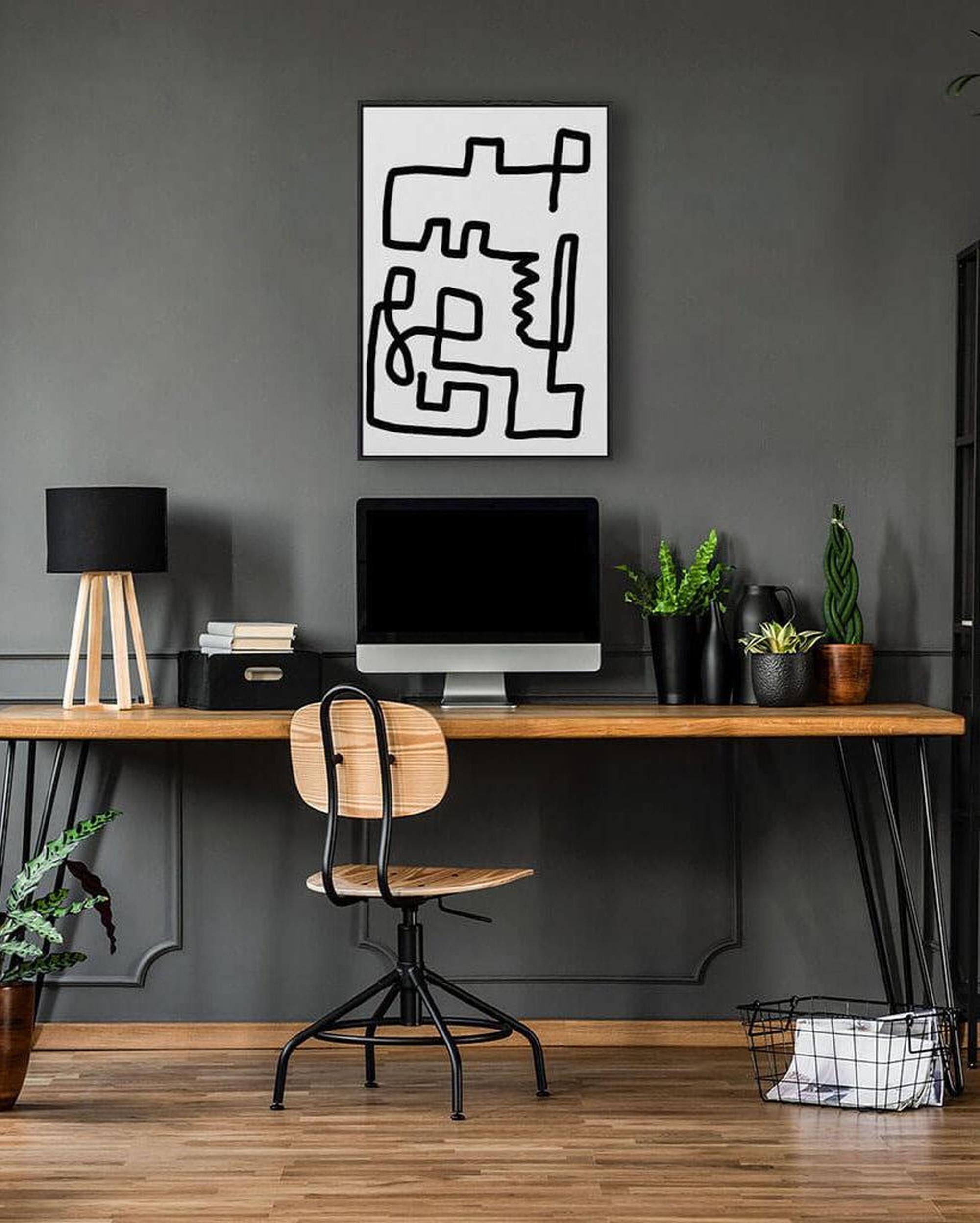 Modern home office with a wooden desk, chair, and abstract wall art.