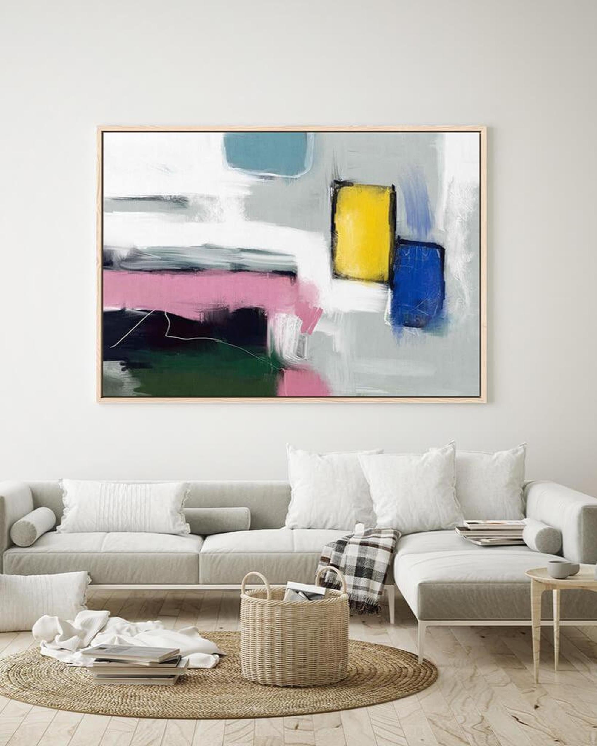 Abstract painting in a modern living room with a sofa and decor items.