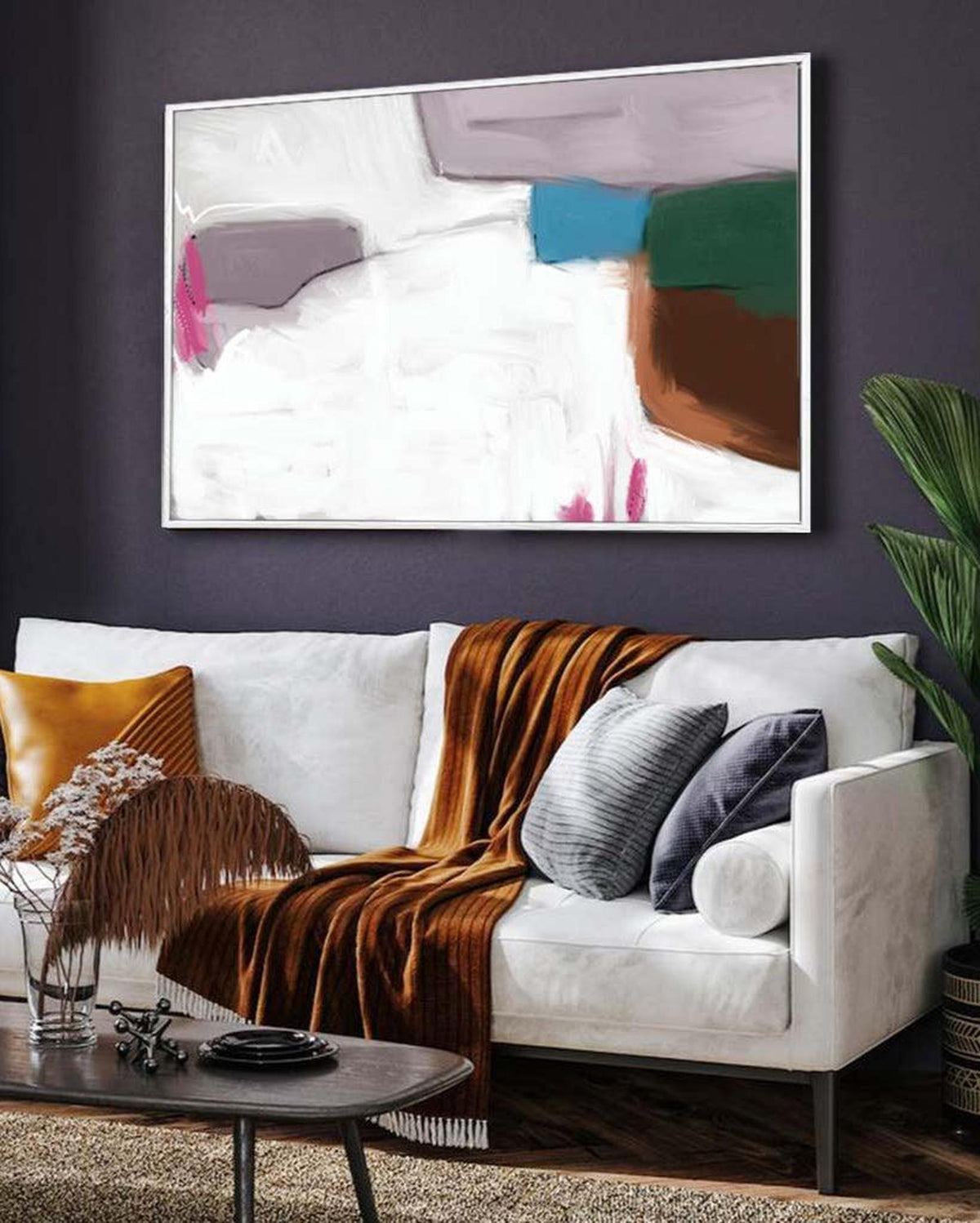 Living room with a white sofa, abstract art on the wall, and decorative items.