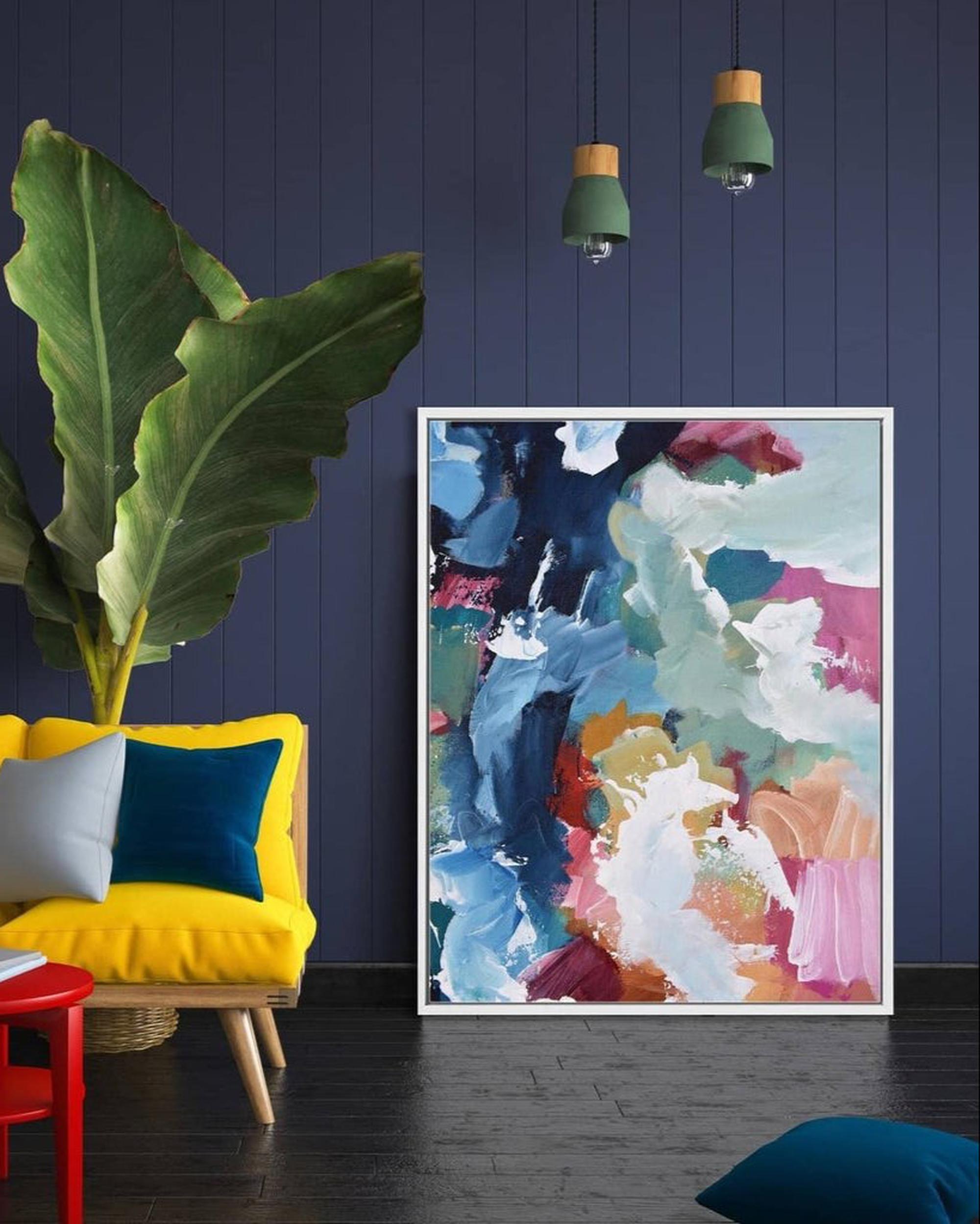 Colorful abstract painting in a modern living room with a yellow couch and plant.