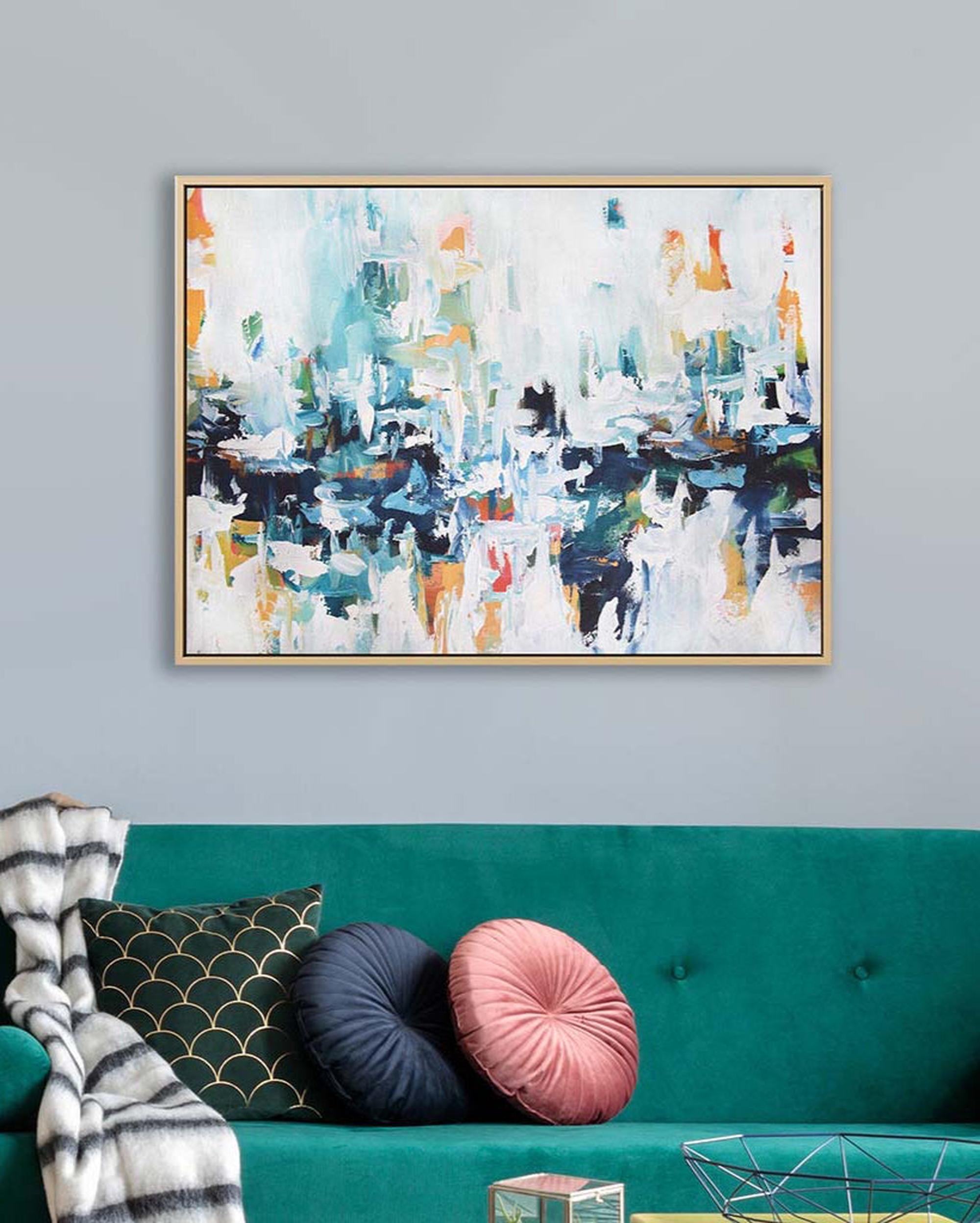 Abstract painting on a wall above a teal sofa with decorative pillows.