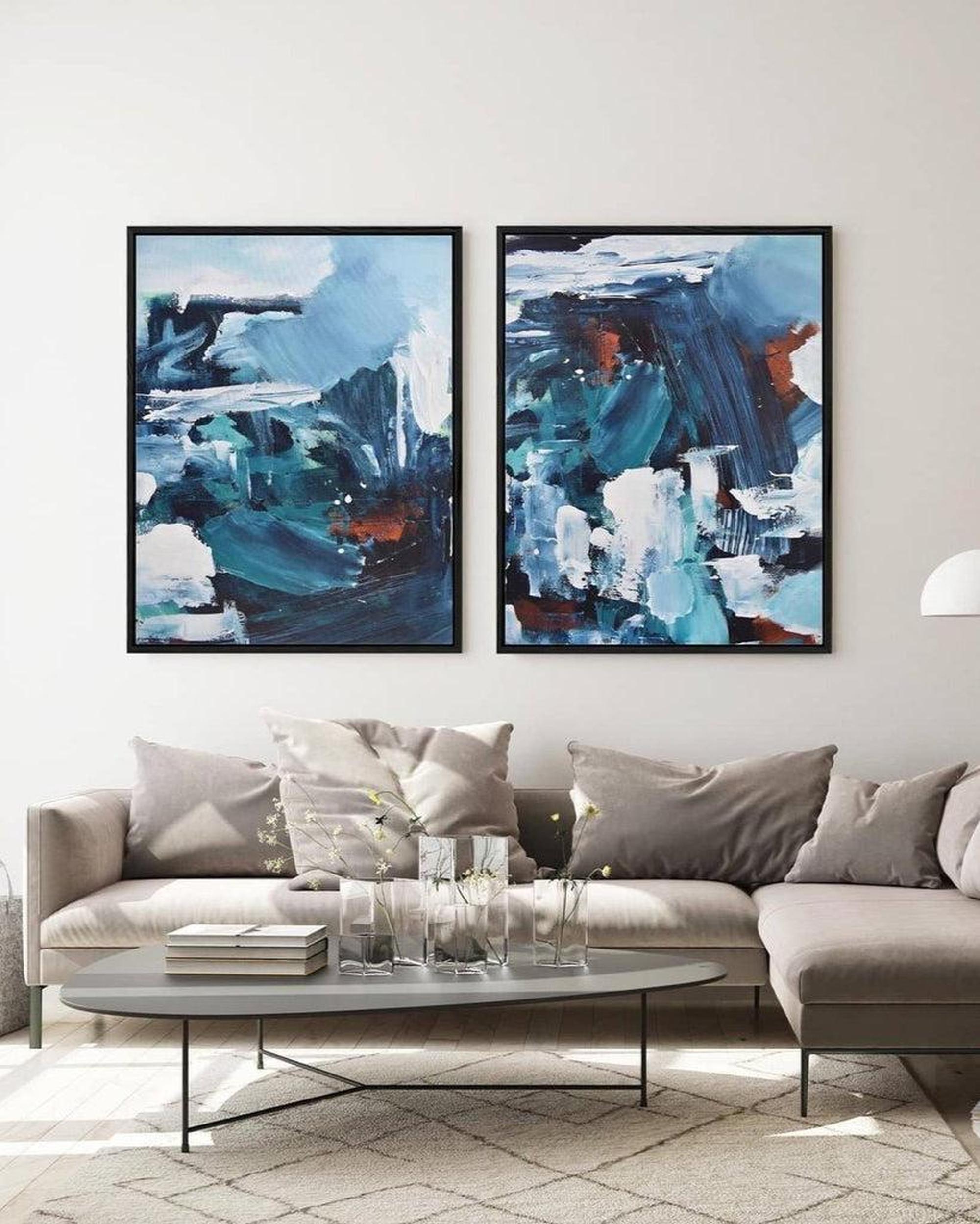 Two abstract paintings on a wall above a sofa in a living room.