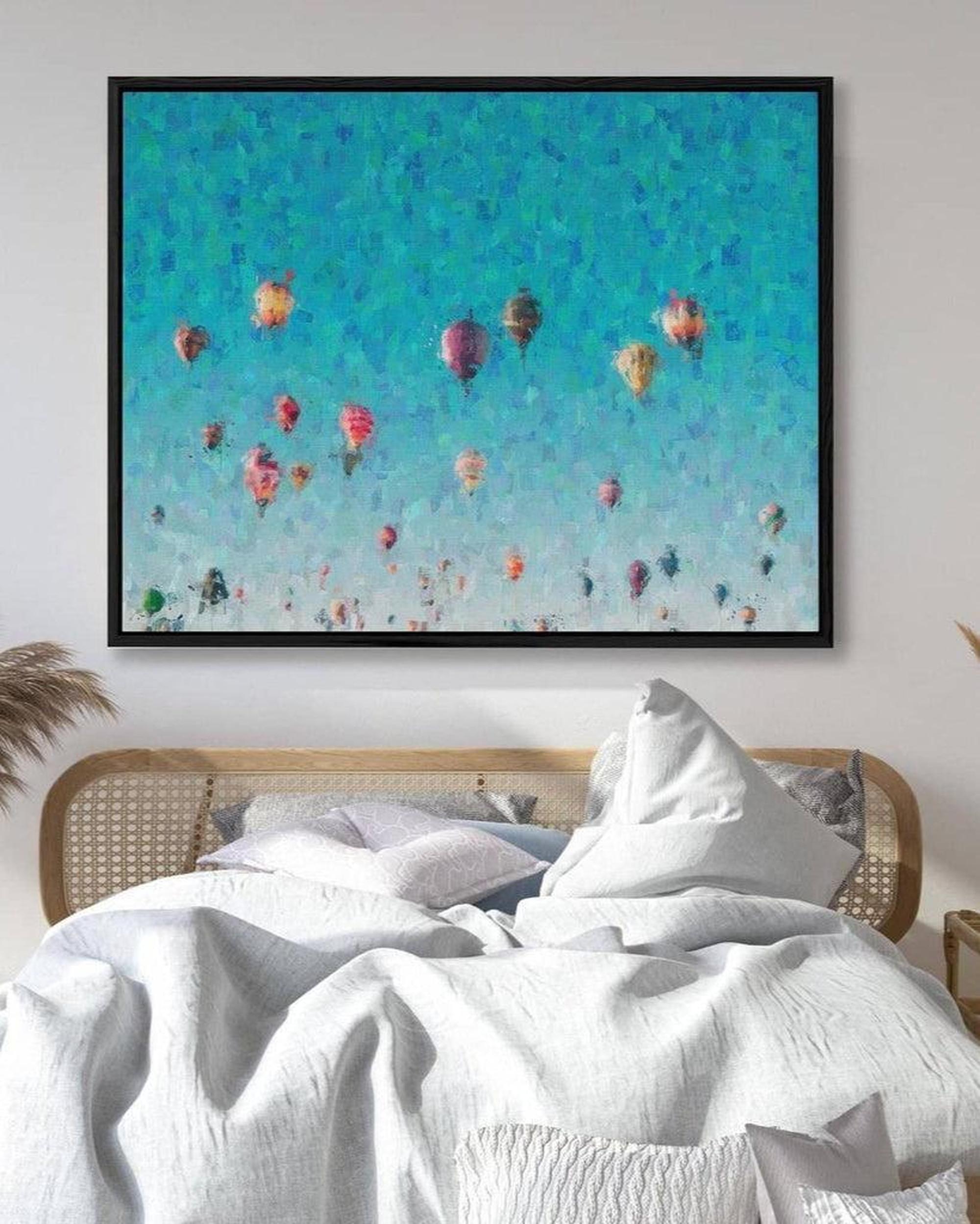 Framed artwork of colorful hot air balloons against a blue sky above a bed.