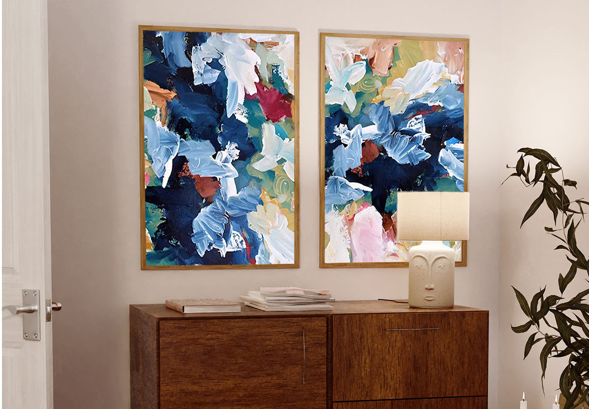 a set of 2 extra large abstract pictures on a wall above a sideboard 