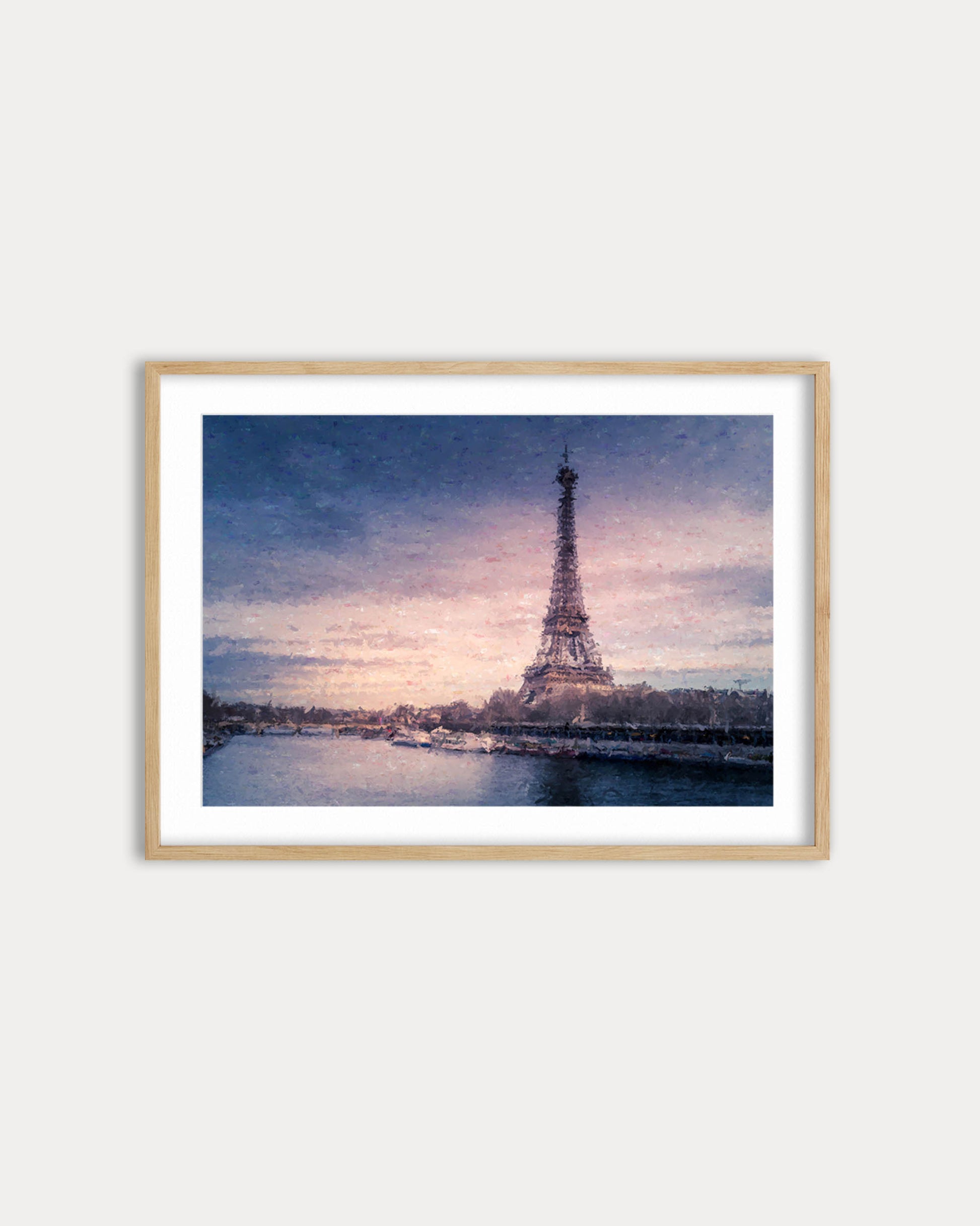 Framed artwork of the Eiffel Tower at sunset with a wooden frame on a white wall.