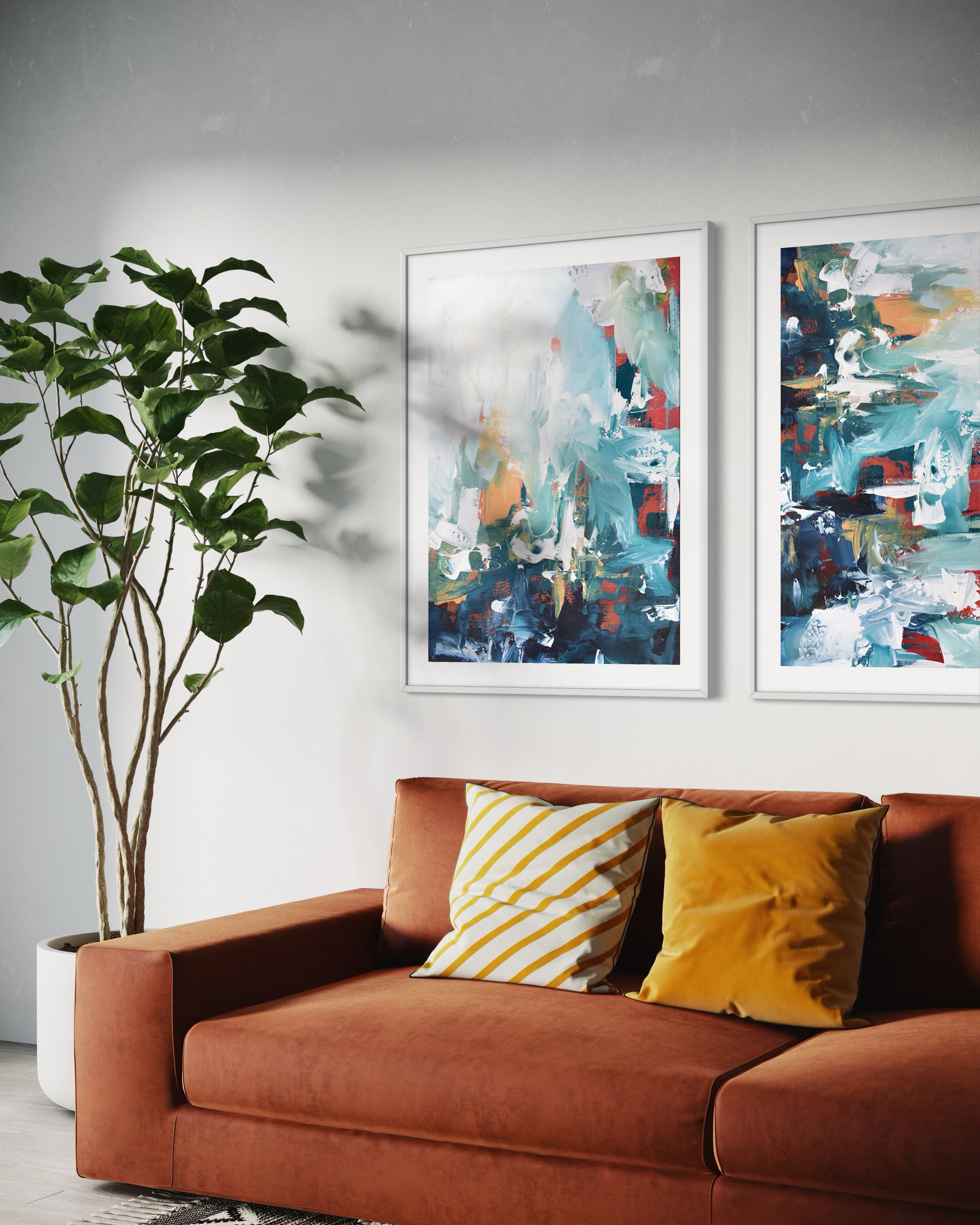 Brown sofa with yellow and white striped pillows, two abstract paintings on the wall, and a potted plant.