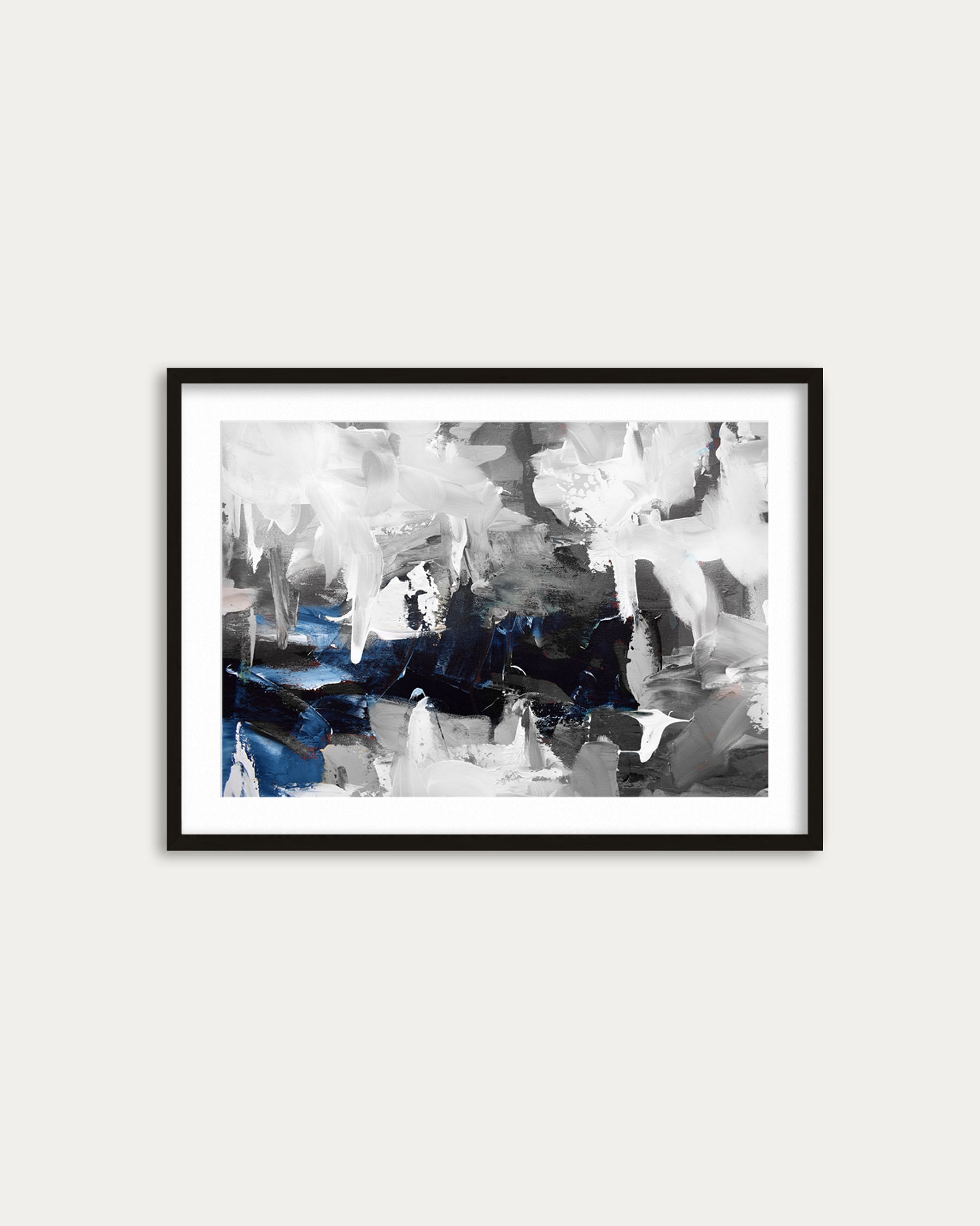 Framed abstract art print with black, white, and blue colors on a white wall.