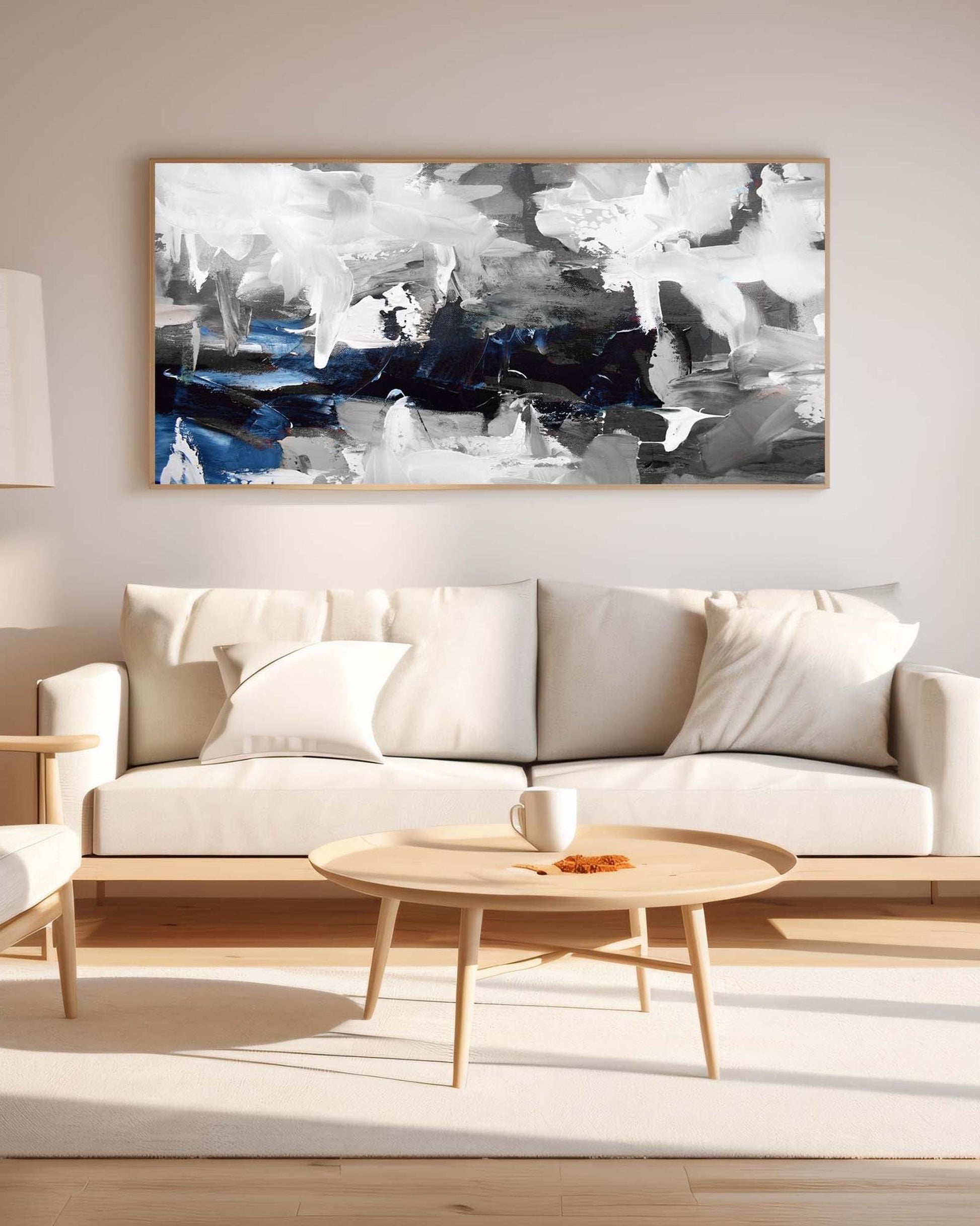 Modern living room with a beige sofa, wooden coffee table, and abstract painting on the wall.