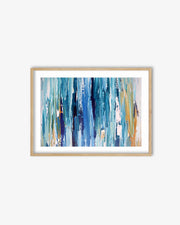 Framed abstract art print with blue and gold brushstrokes on a white wall