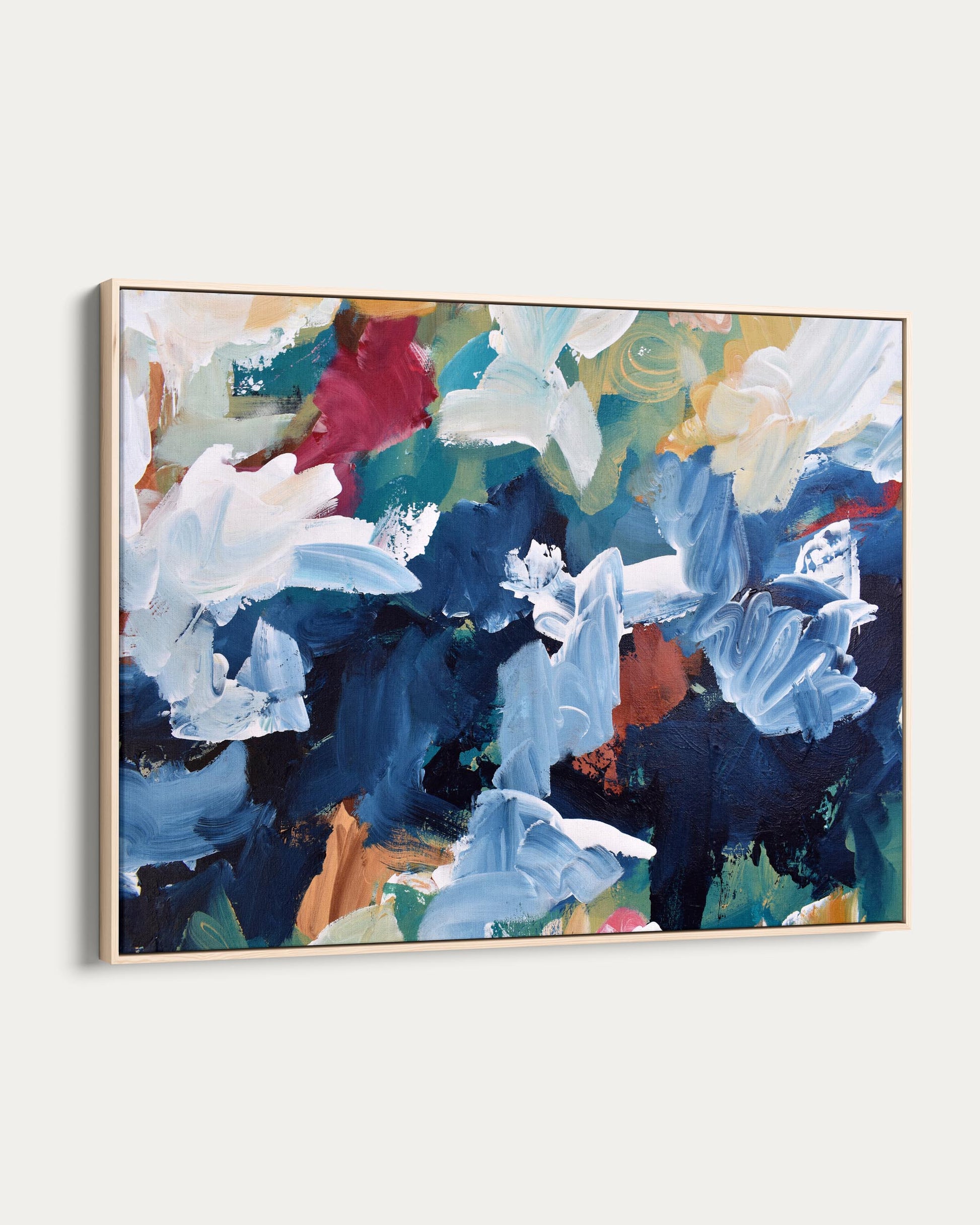 Abstract painting with blue, white, and red flowers in a gold frame on a white background