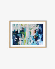 Framed abstract art print with blue and green colors on a white wall