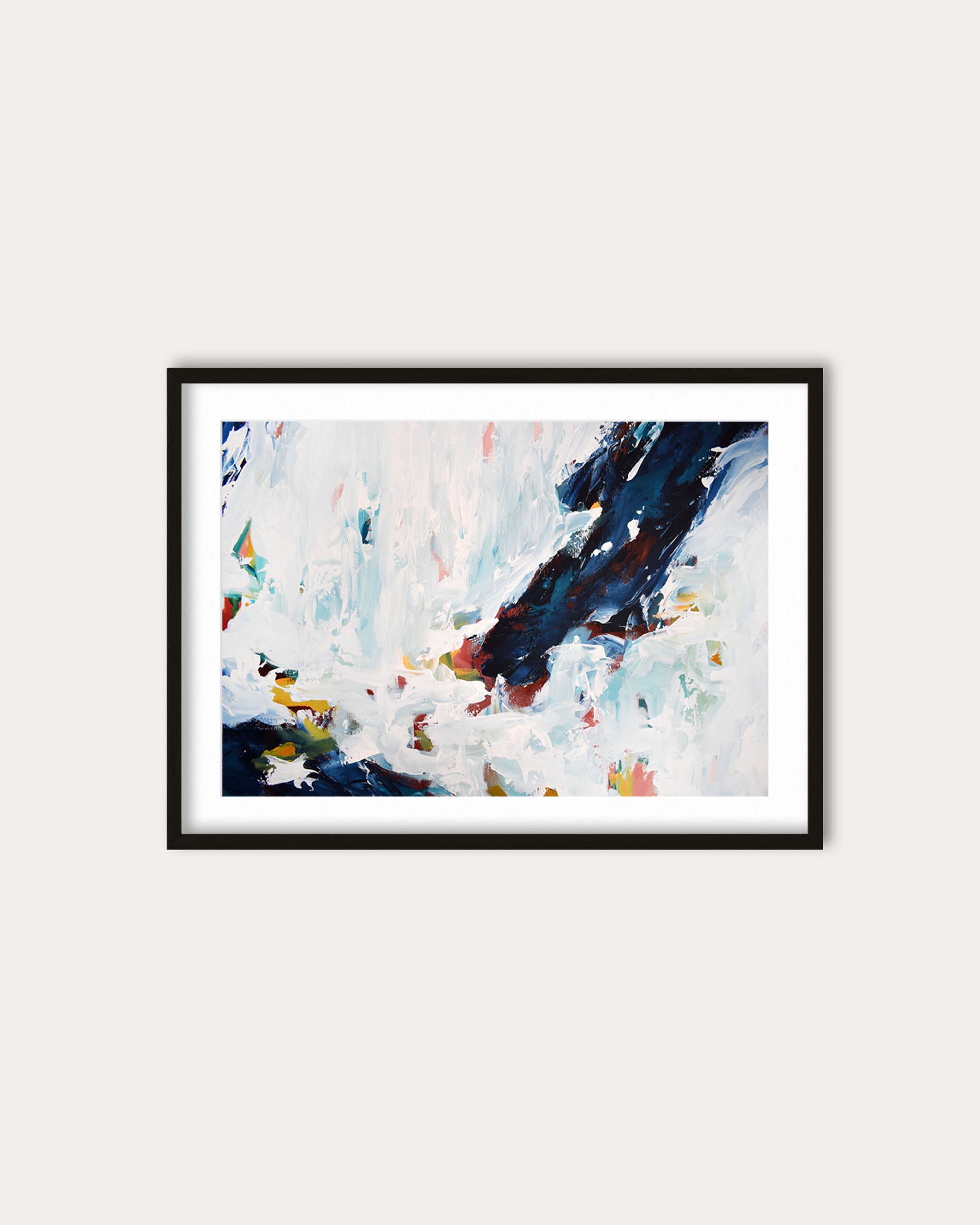 Framed abstract painting with colorful splashes on a white wall