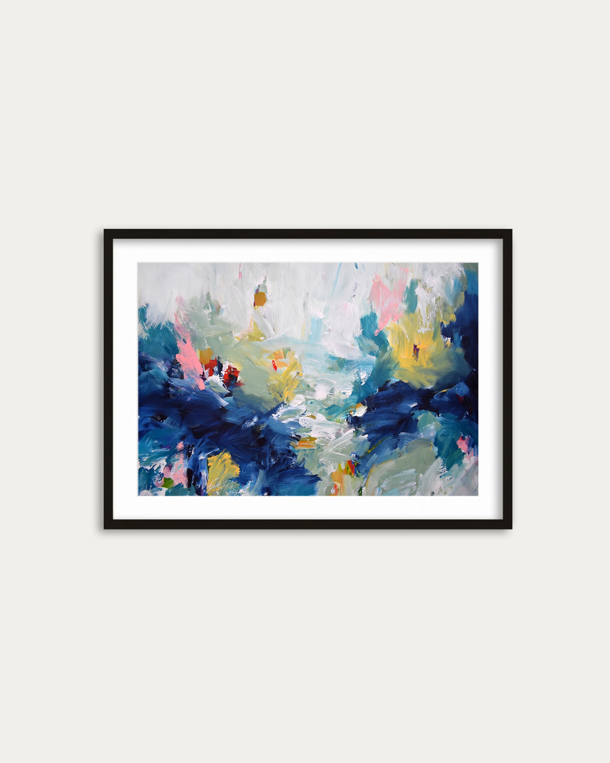 Framed abstract painting with blue, yellow, and pink colors on a white wall.