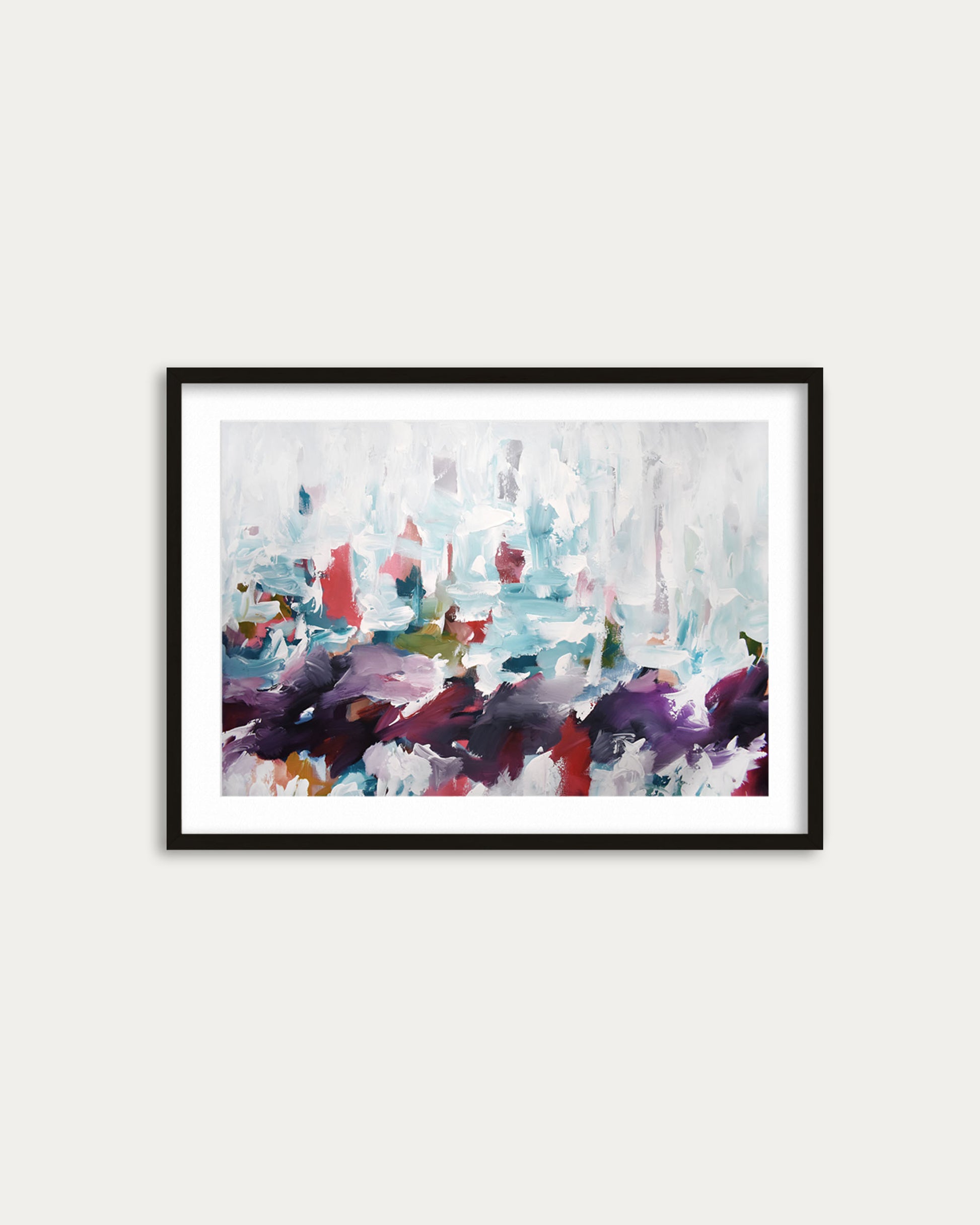 Framed abstract painting with colorful brushstrokes on a white wall