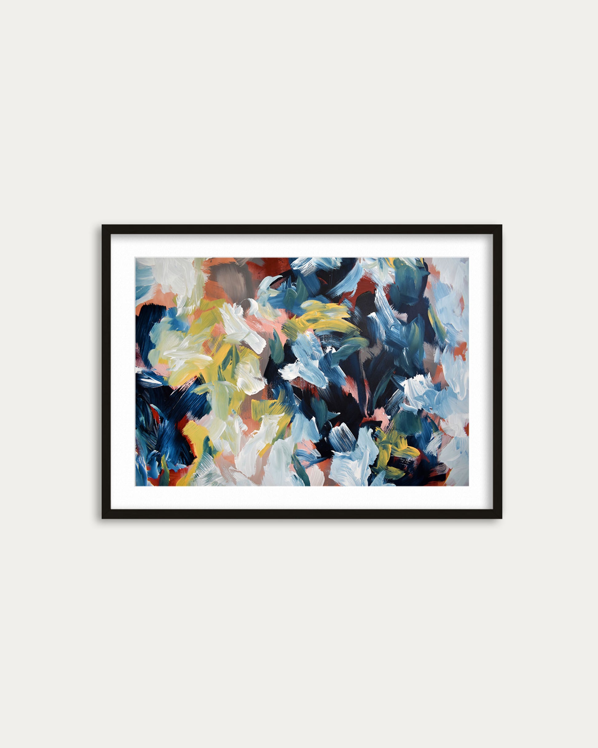 Framed abstract painting with multicolors on a white wall
