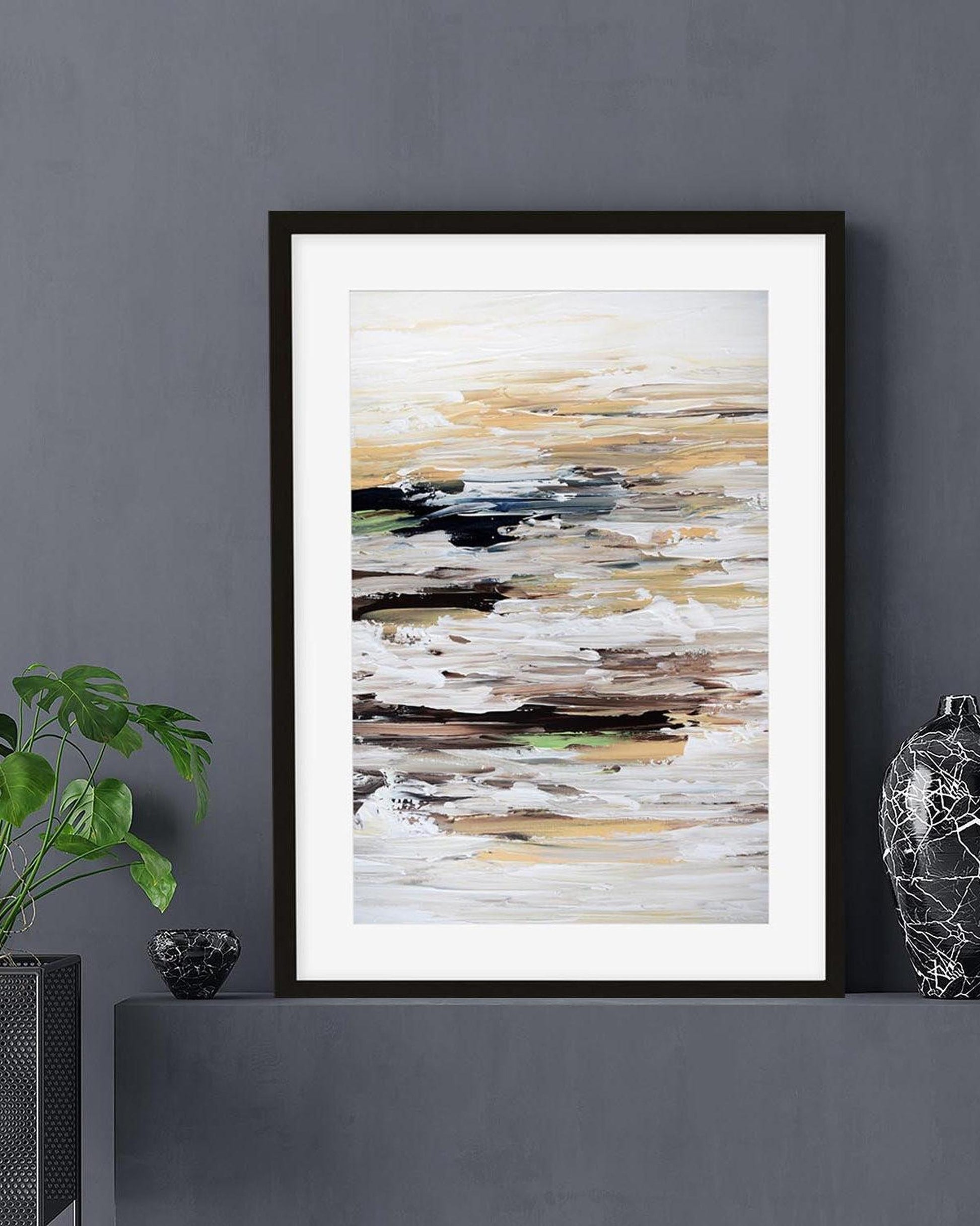 Framed abstract art piece on a dark gray wall with decorative items.