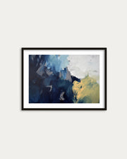 Framed abstract art print with blue and yellow colors on a white wall