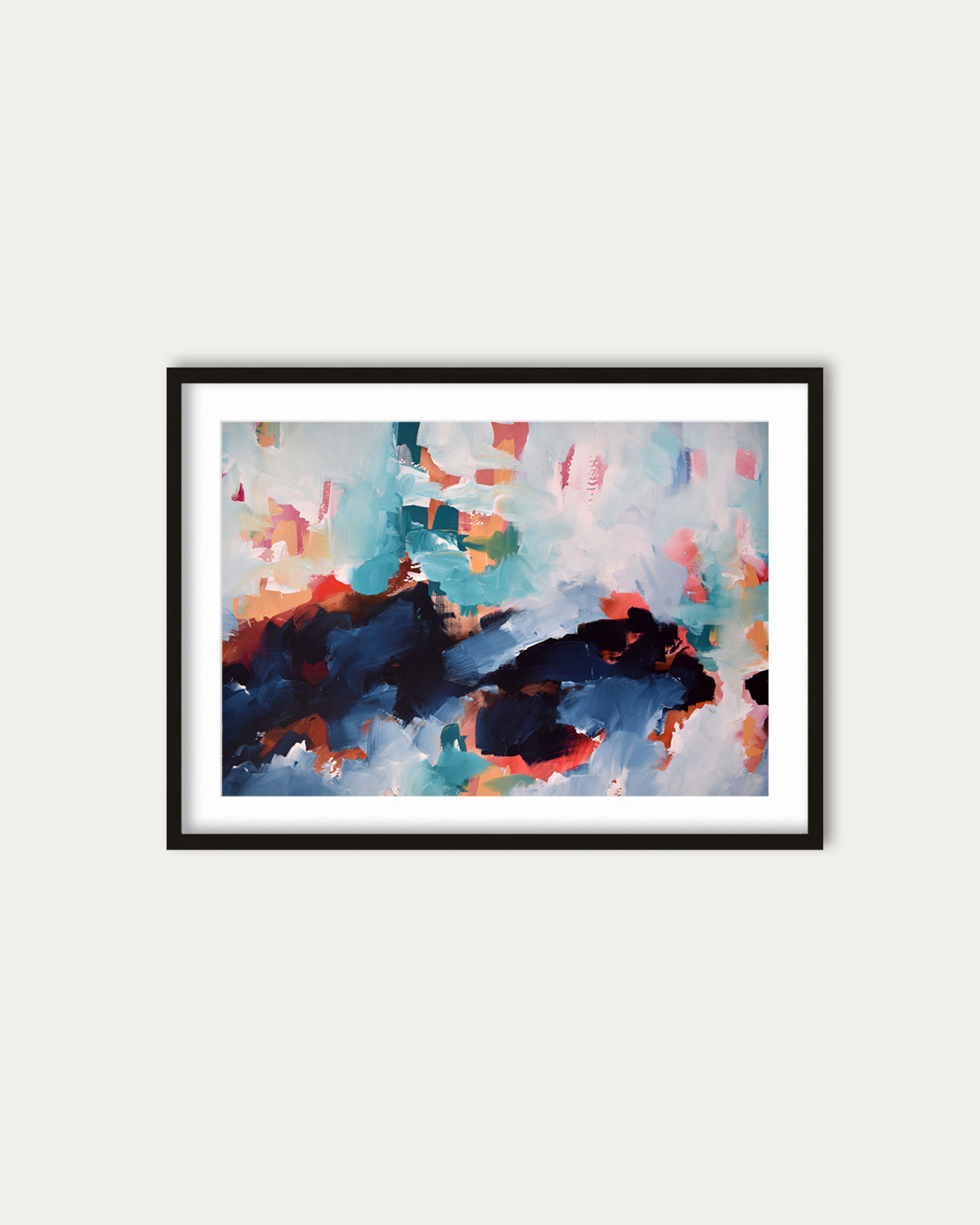 Framed abstract painting with colorful splashes on a white wall