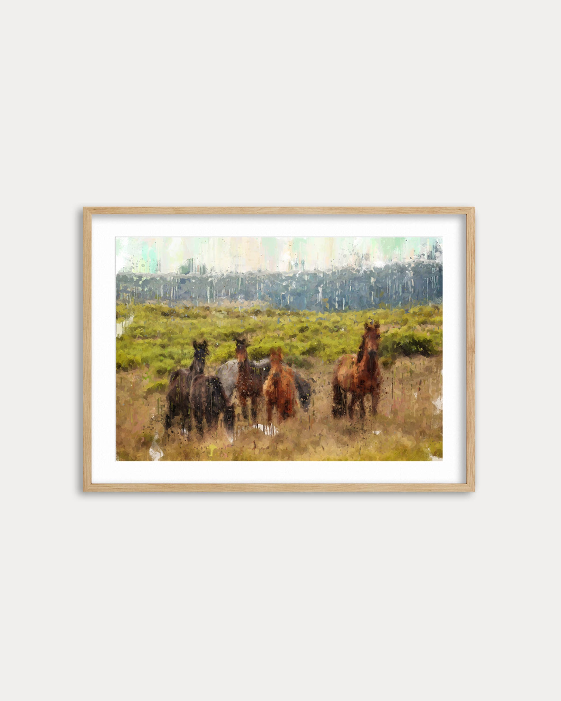 Framed artwork of horses in a field on a white wall