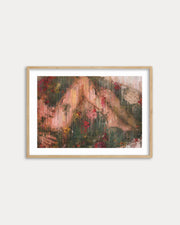 Framed abstract painting with earthy tones on a white wall