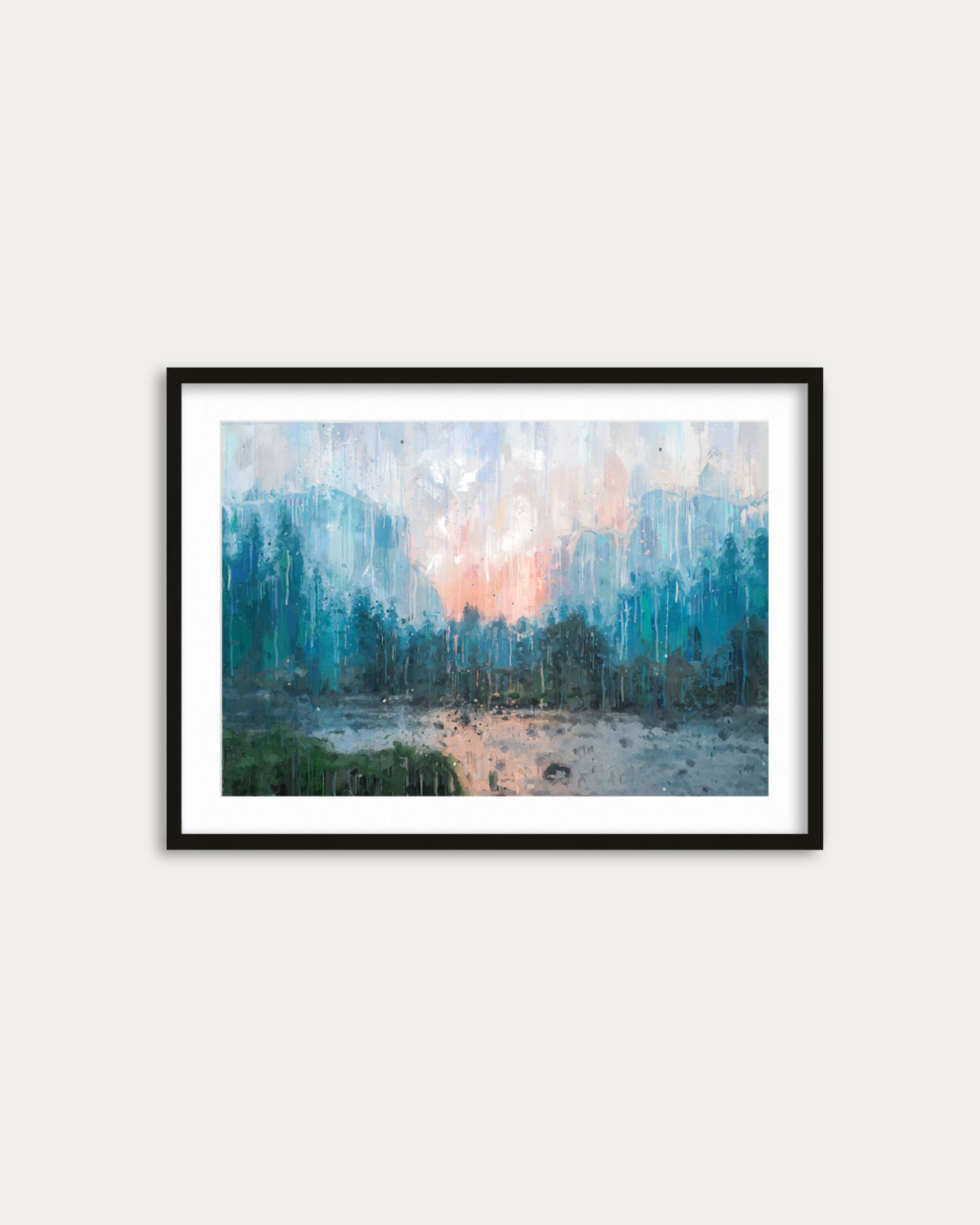 Framed artwork of a forest scene with a sunset over water on a white wall.
