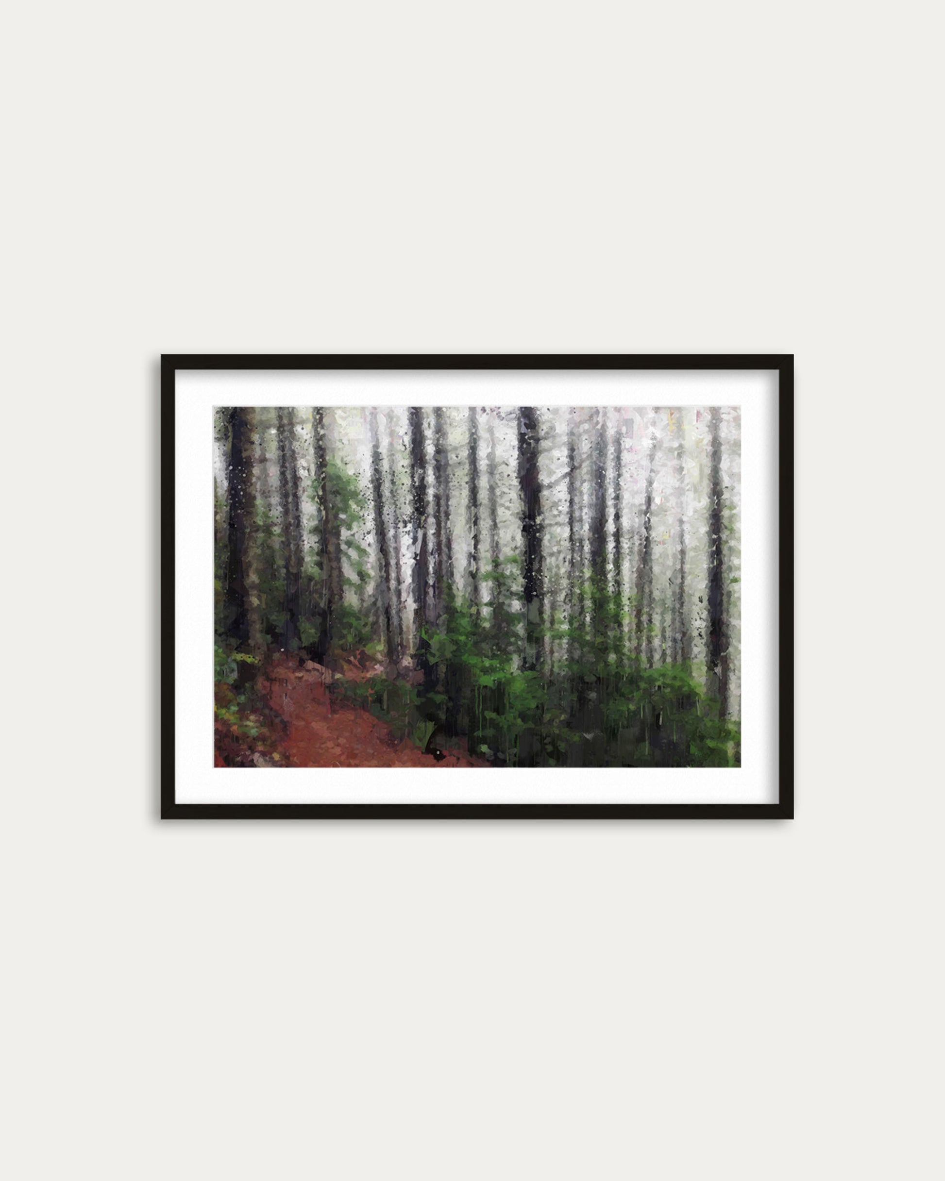 Framed photograph of a forest path on a white wall