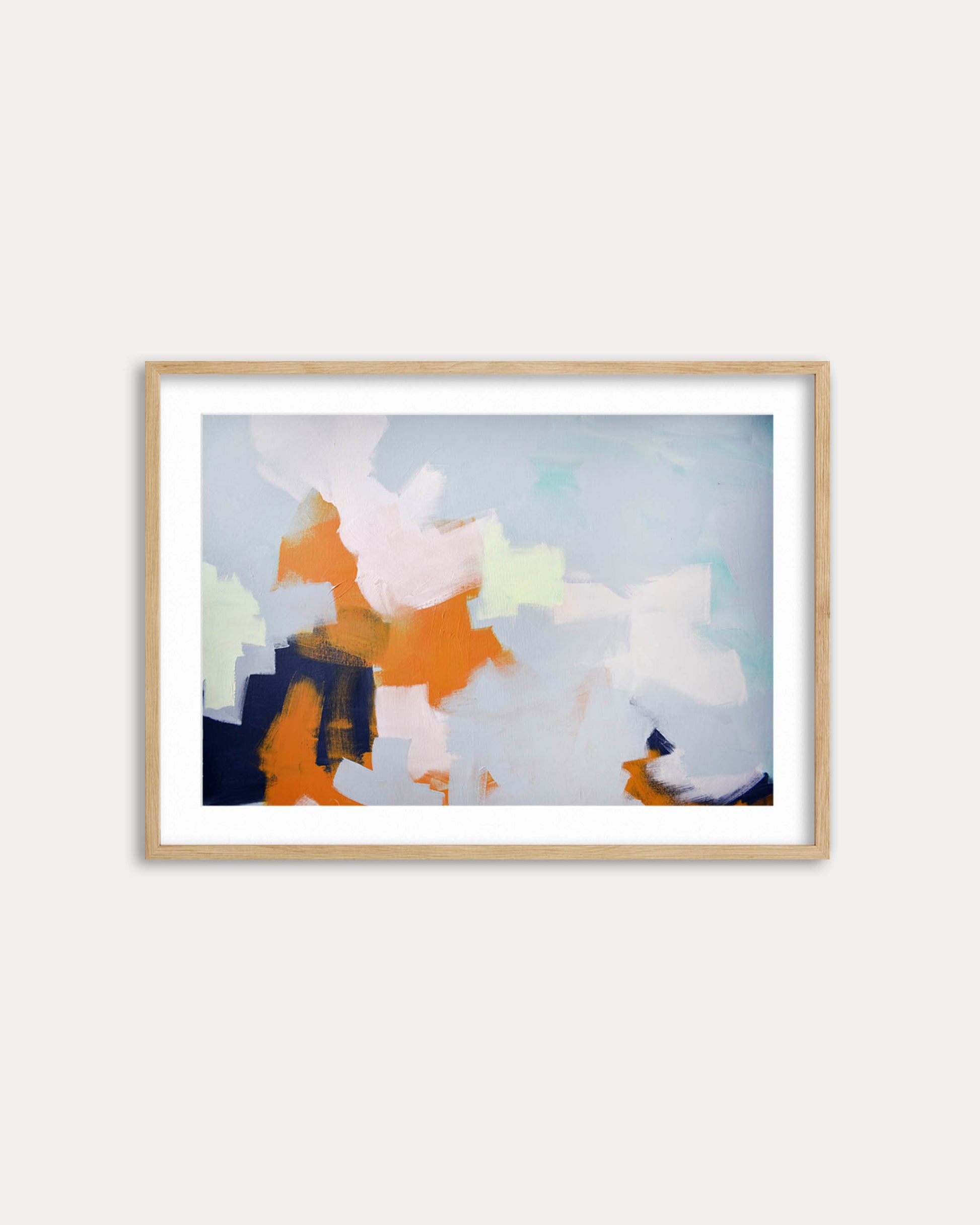 Framed abstract artwork with colorful brush strokes on a white wall