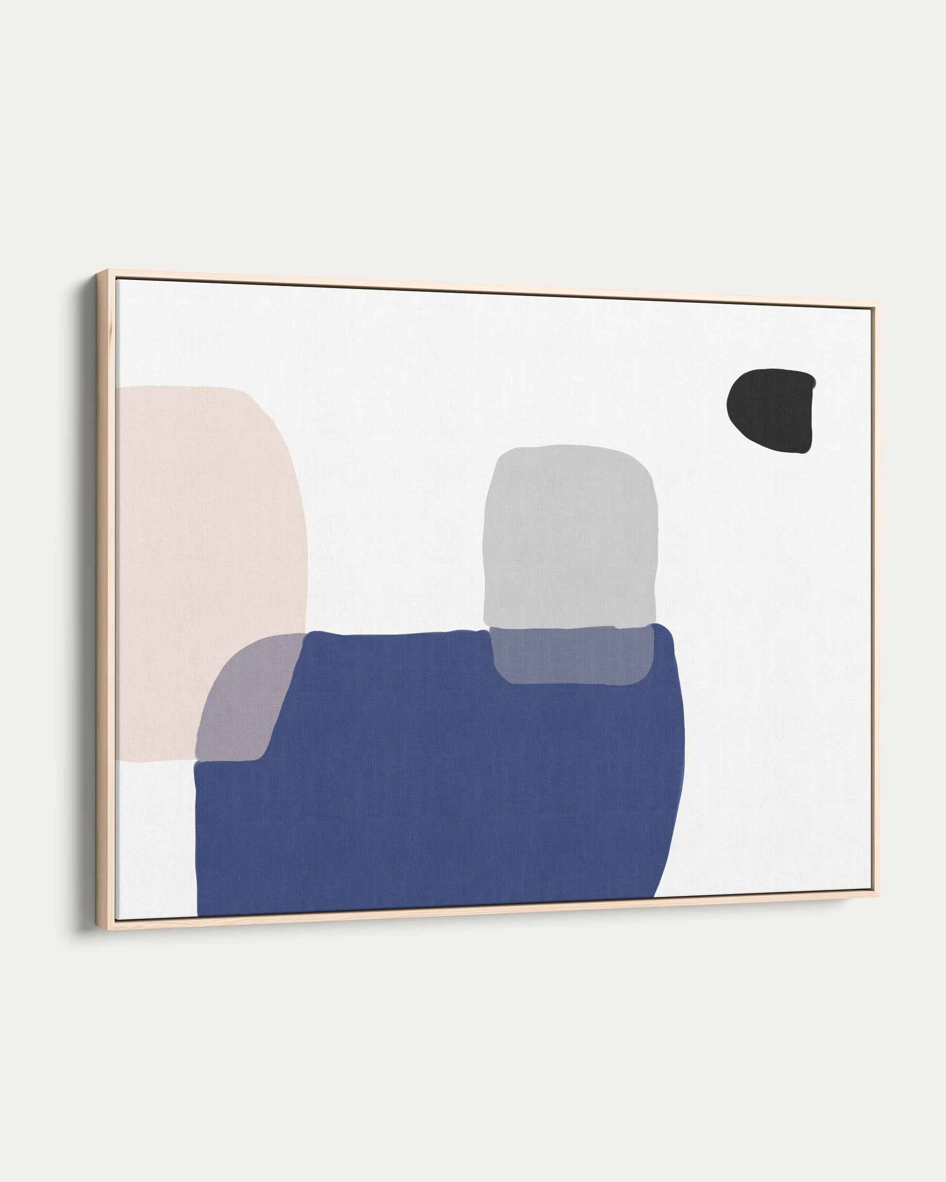 Abstract art print with geometric shapes in a gold frame on a white wall