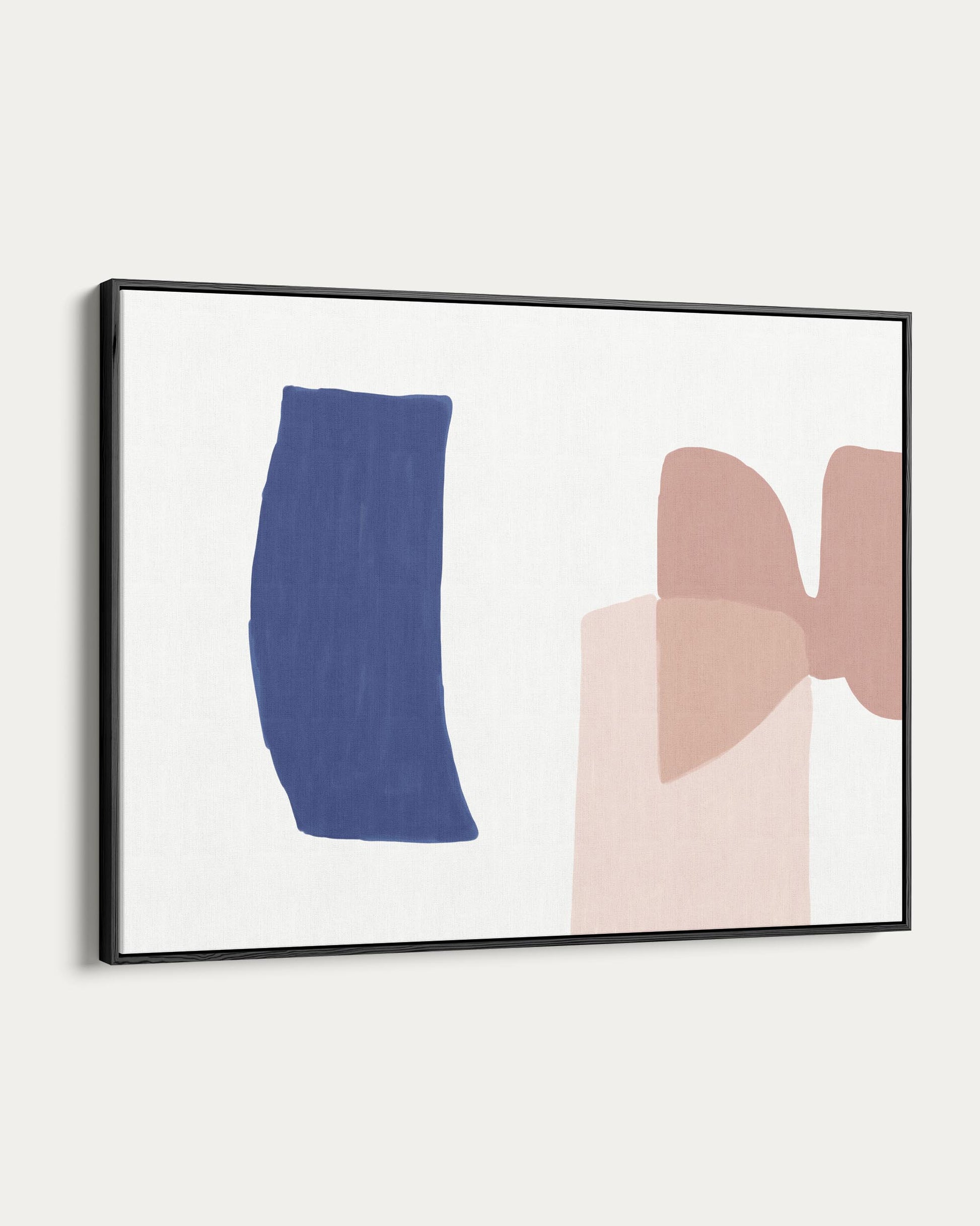 Framed abstract art with blue and pink shapes on a white wall