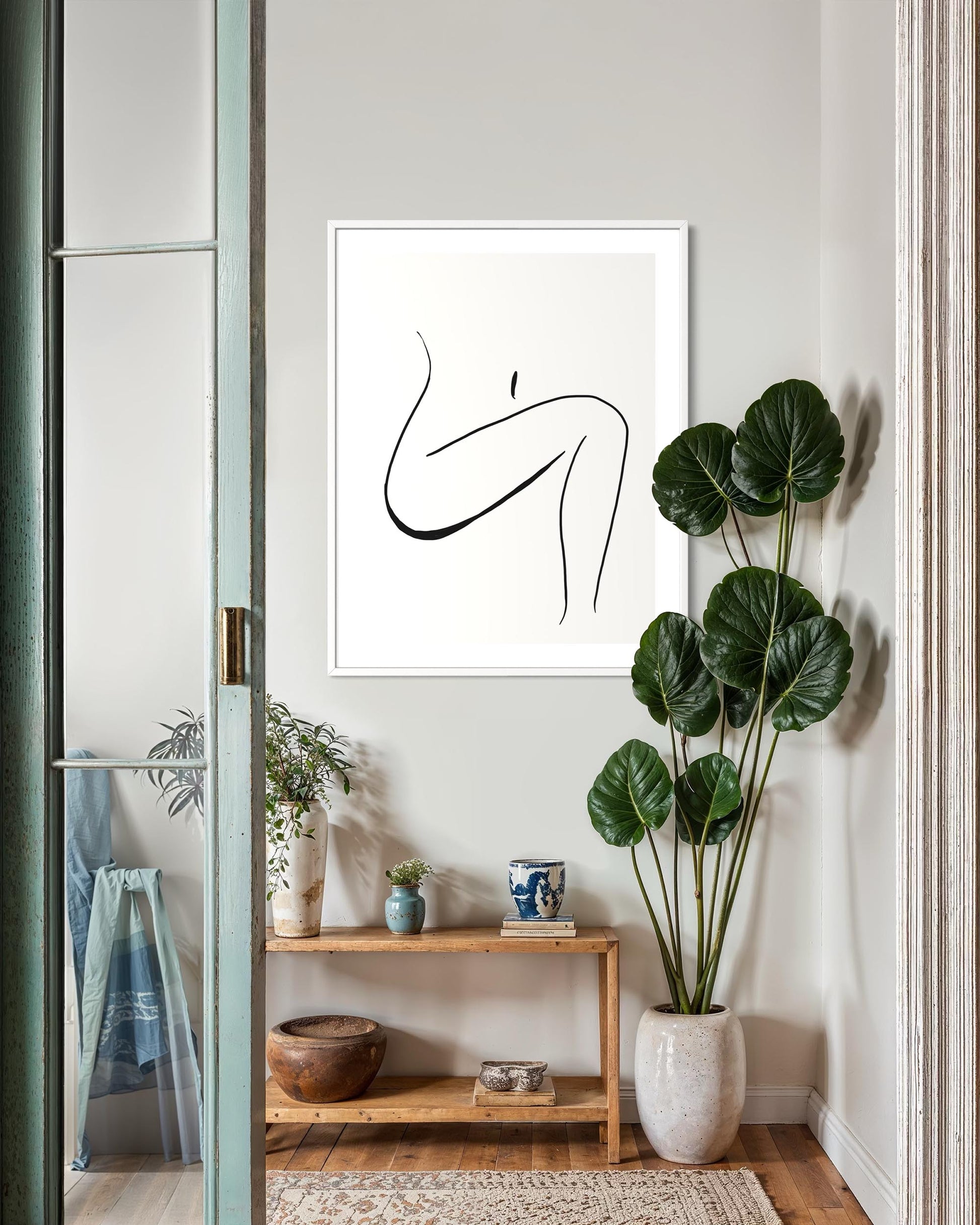 Modern interior with abstract art, plants, and a wooden side table.