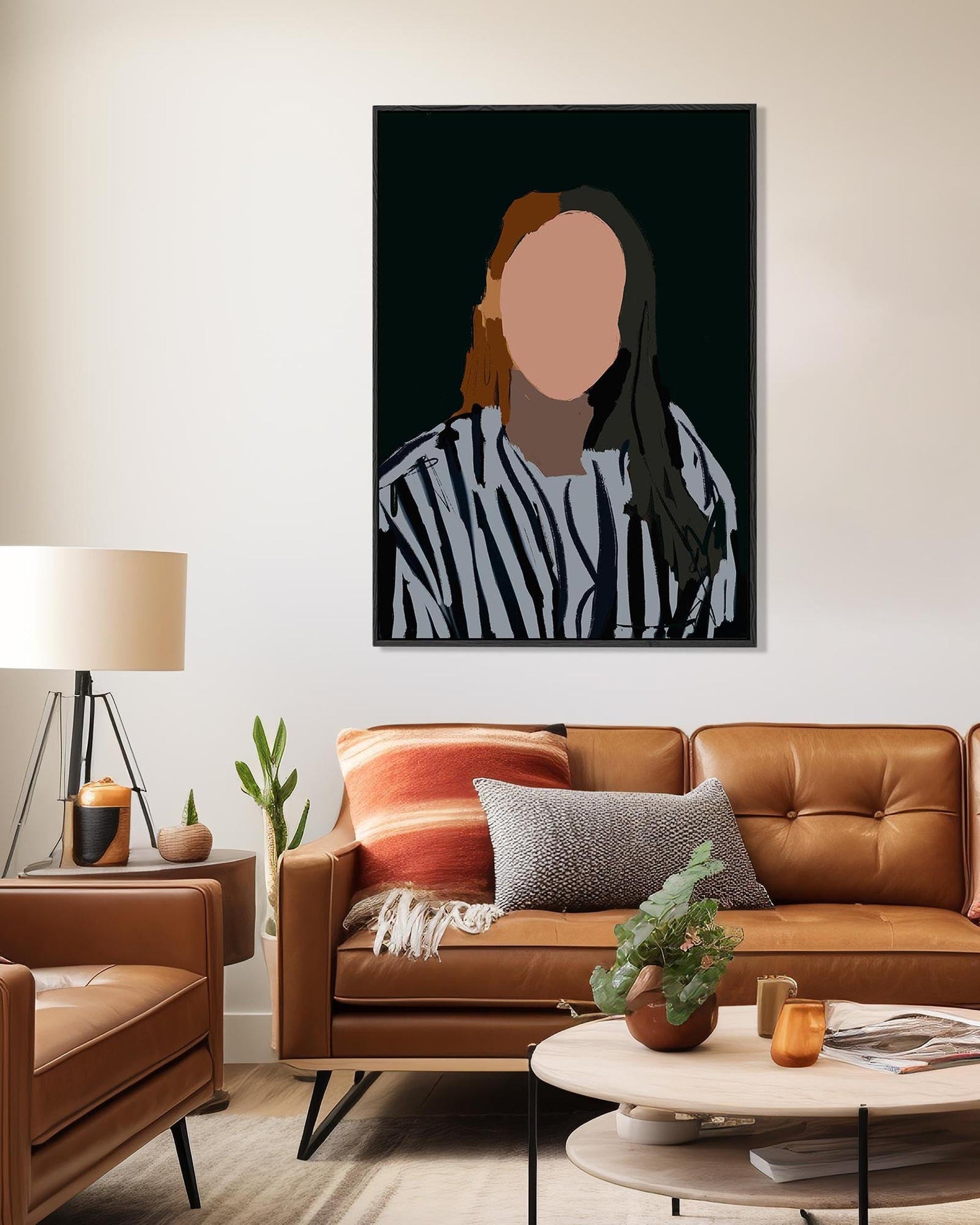 Living room with a brown leather sofa, coffee table, and wall art of a person in a striped shirt.