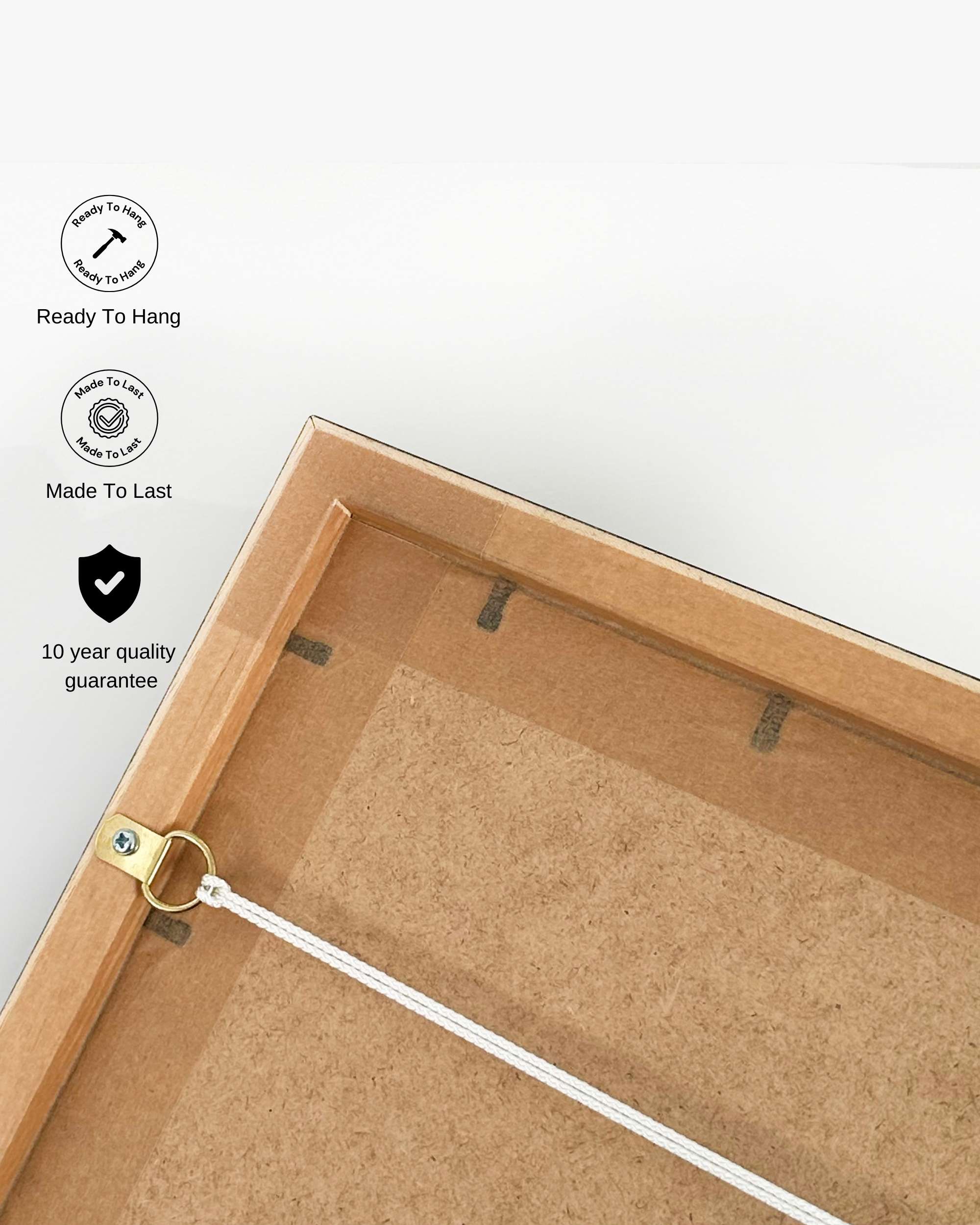 Back of a wooden picture frame with hanging hardware on a white background