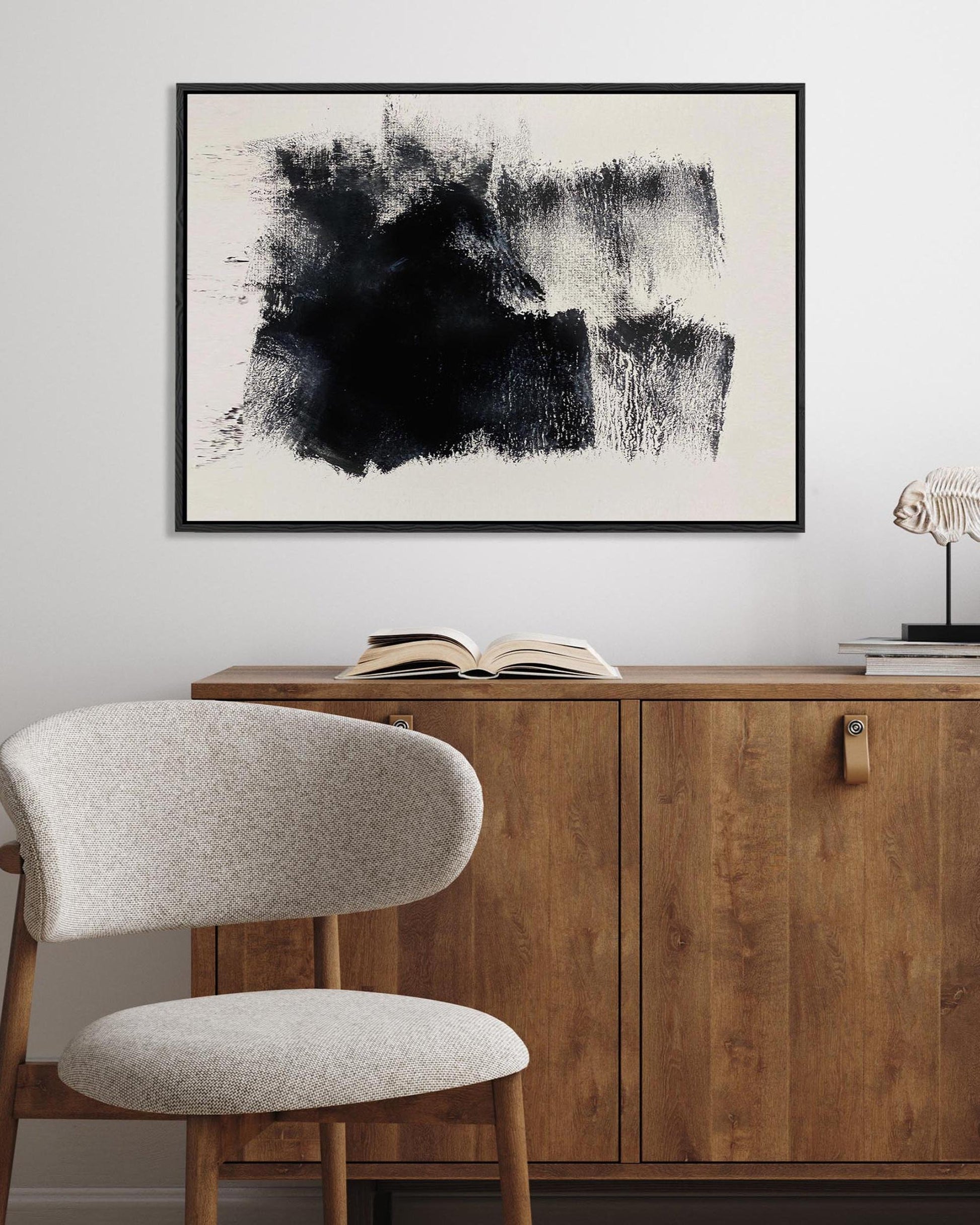 Modern interior with wooden sideboard, abstract art, and chair.