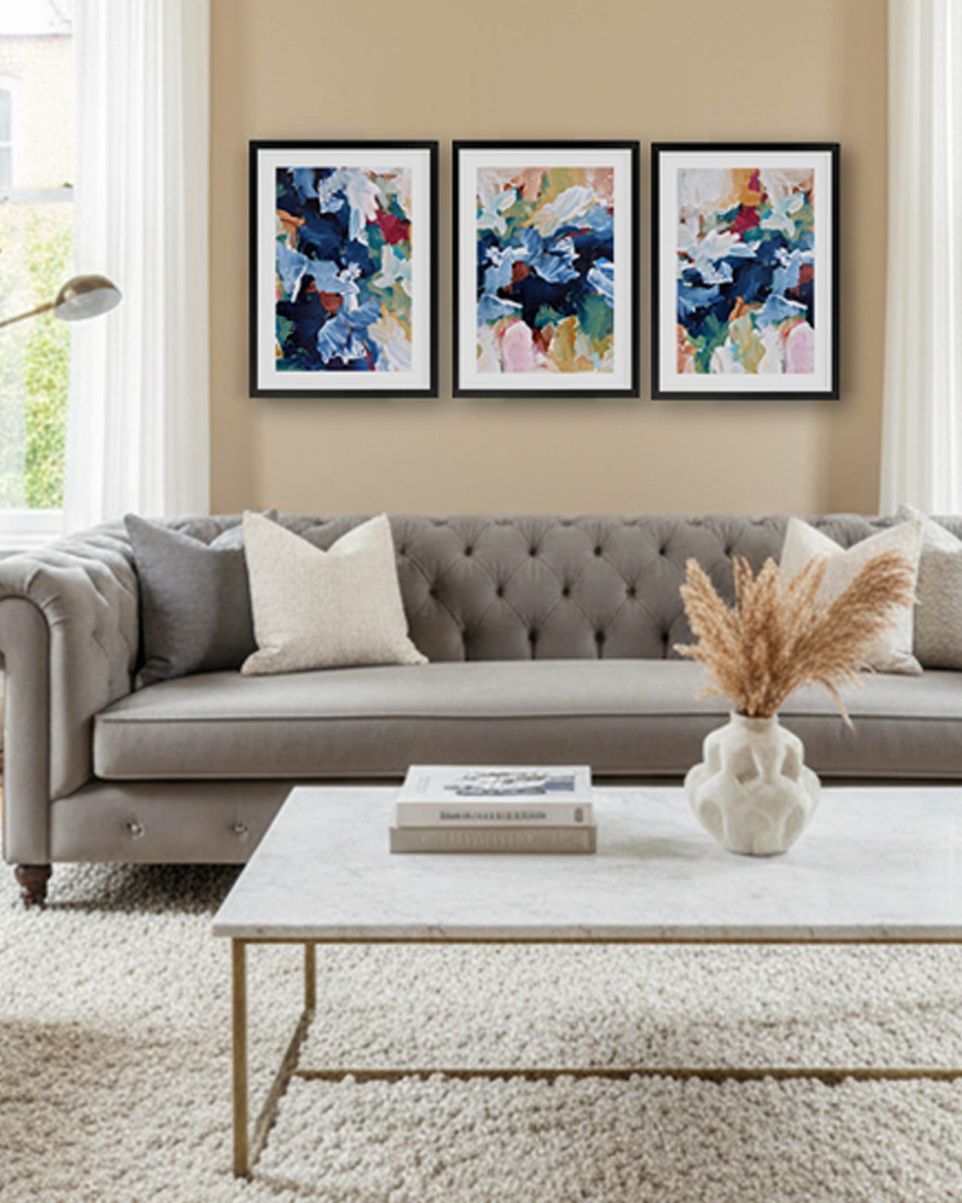 modern living room with grey chesterfield sofa, colourful abstract wall art and thick white pile rug