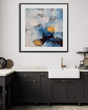 Modern kitchen with black cabinets, white sink, and abstract art on the wall.