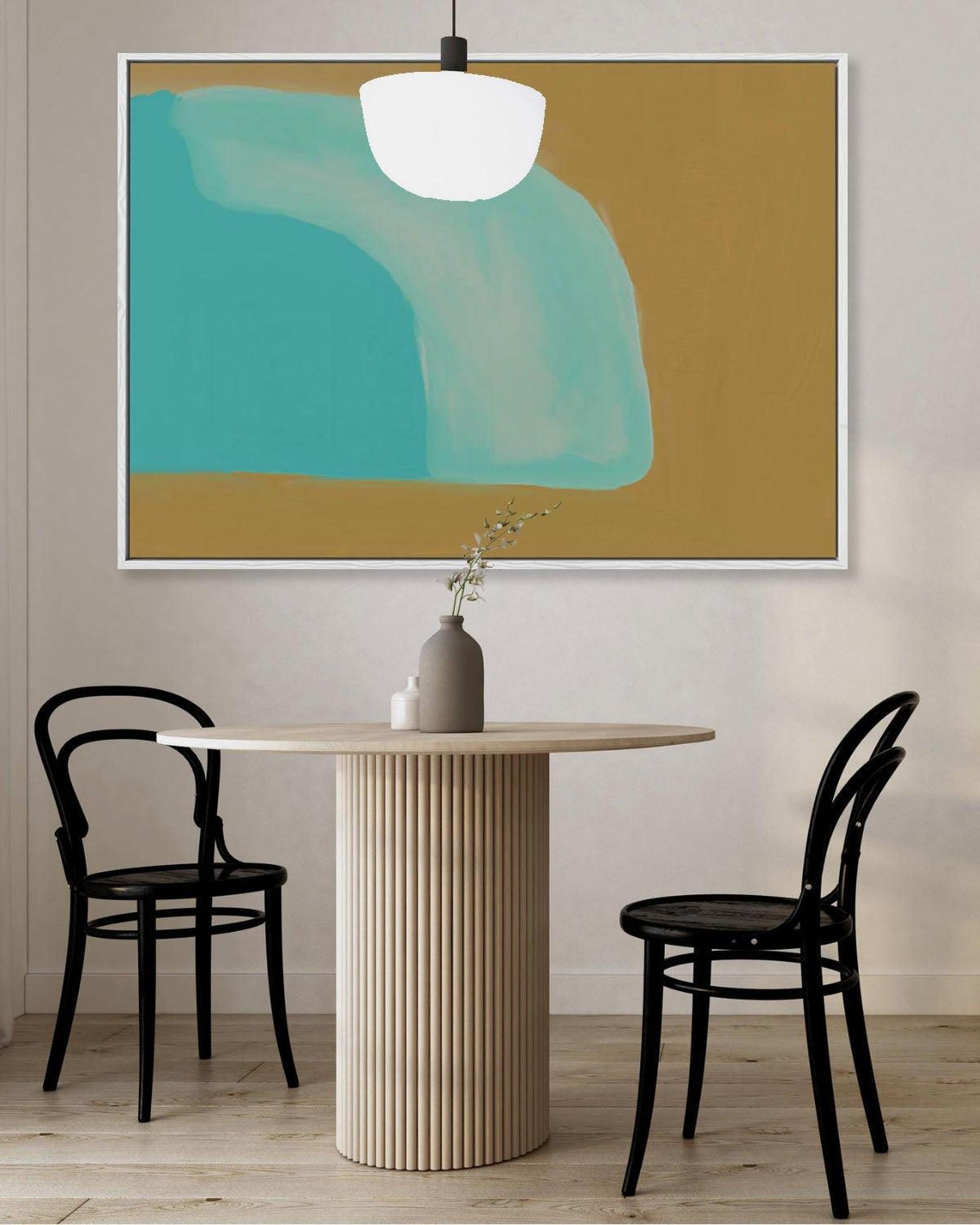 Dining room with a round table and black chairs, abstract art on the wall.