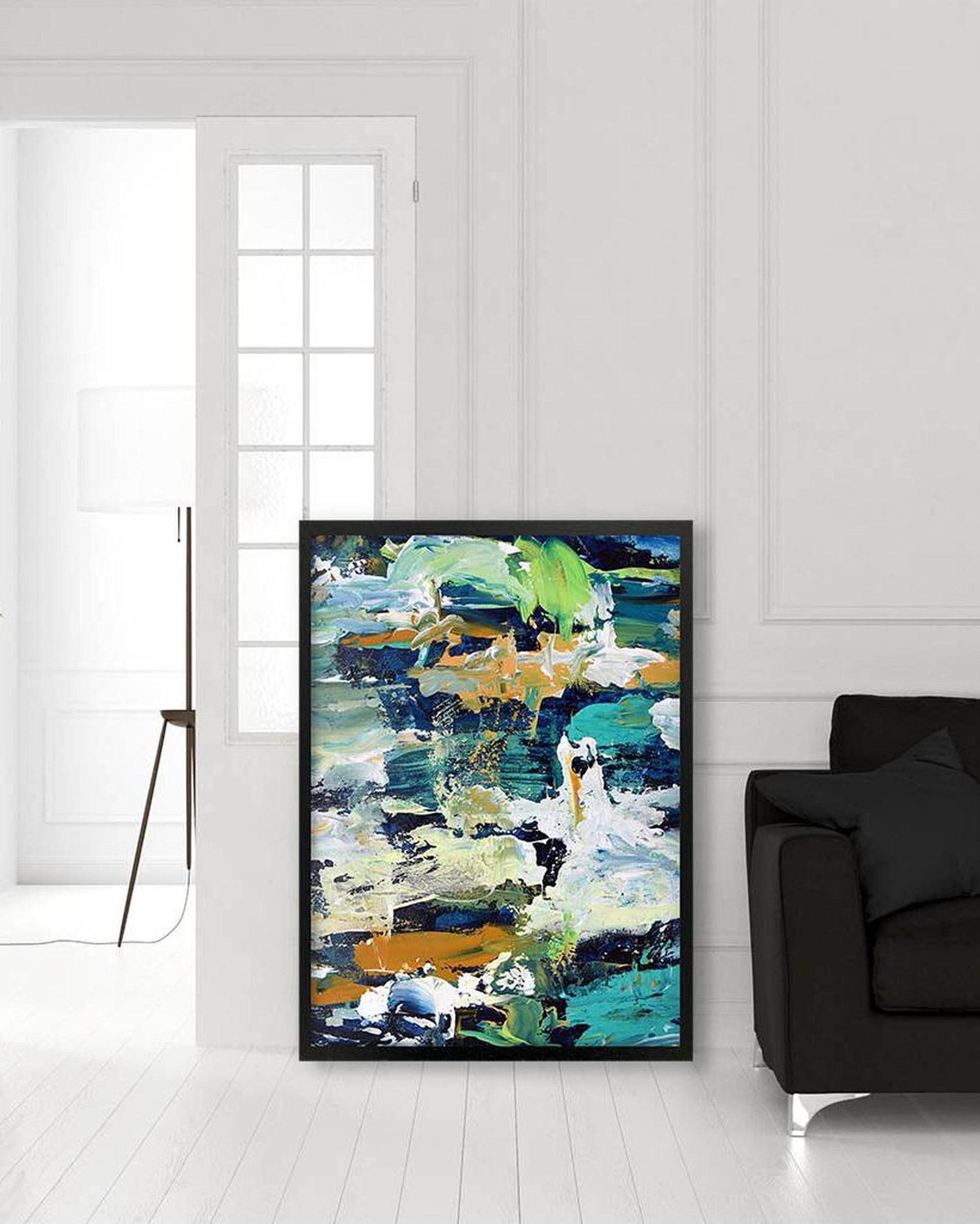 Abstract painting in a modern living room with a black sofa and white walls.