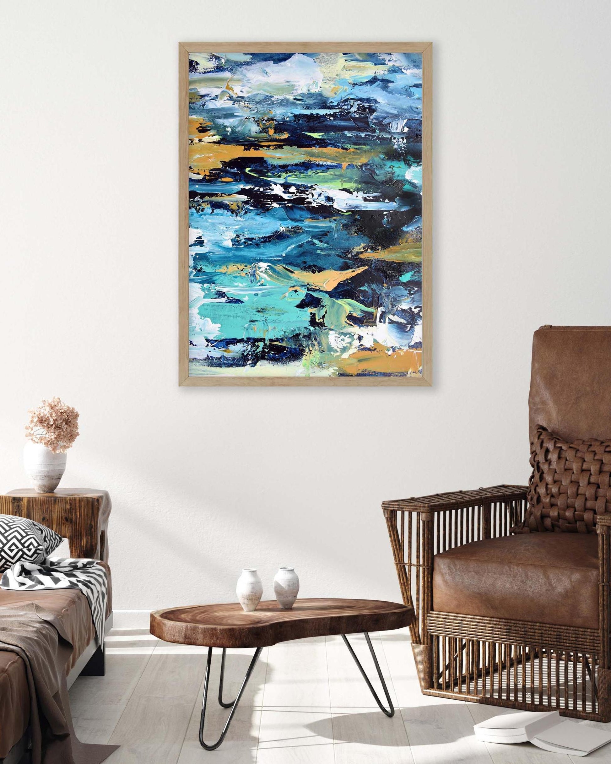 Abstract painting in a living room with a brown armchair and wooden coffee table.