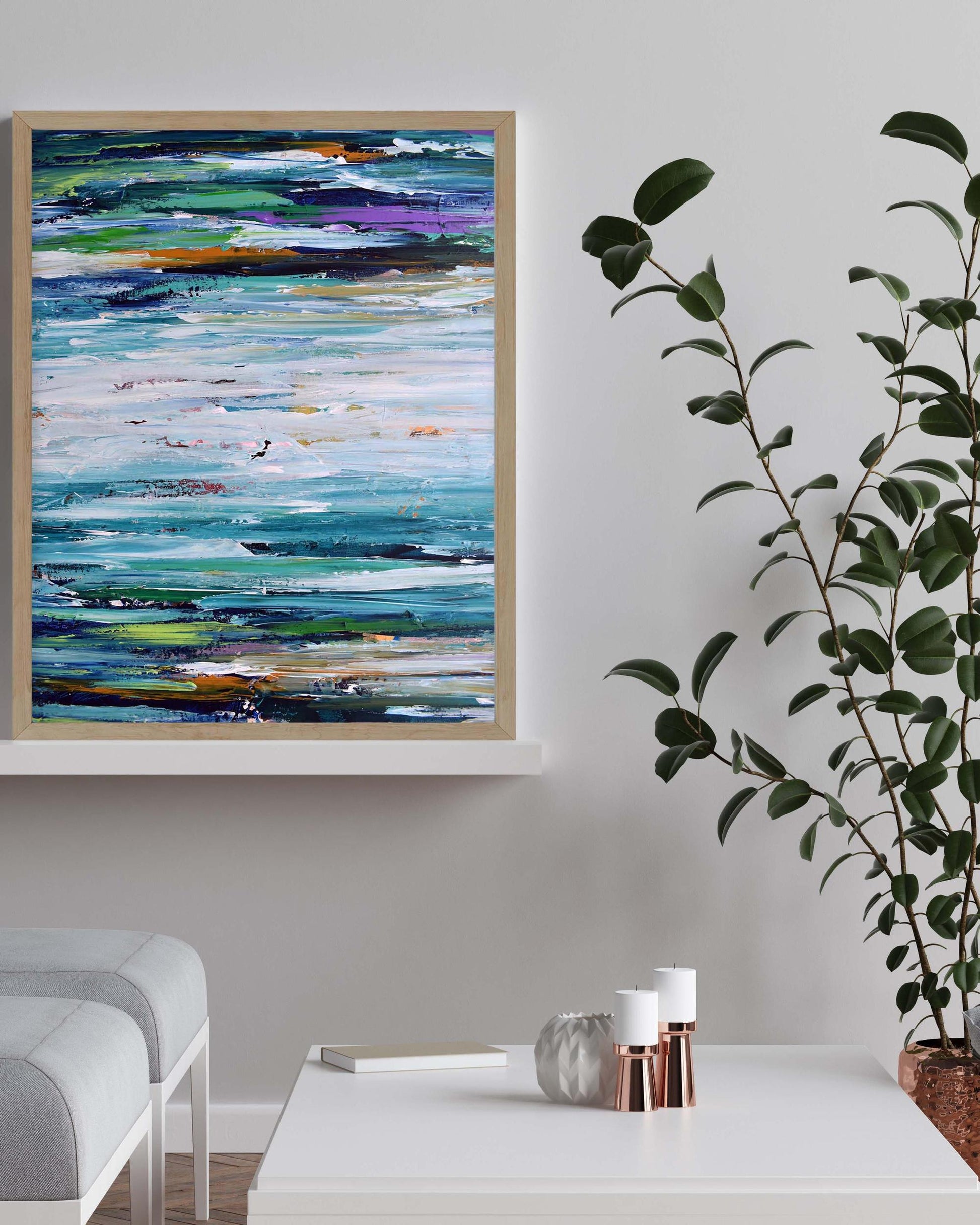 Abstract painting on a wall with a plant and table in the foreground