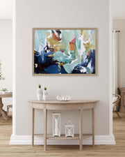 Abstract painting on a wall above a wooden console table with decorative items.