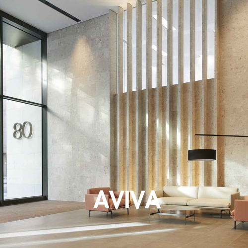 A modern interior lobby with textured stone walls, vertical slatted wood screens, a cream sofa, two blush pink armchairs, a black floor lamp, and large glass windows. The word 'AVIVA' appears prominently in white text near the bottom center.