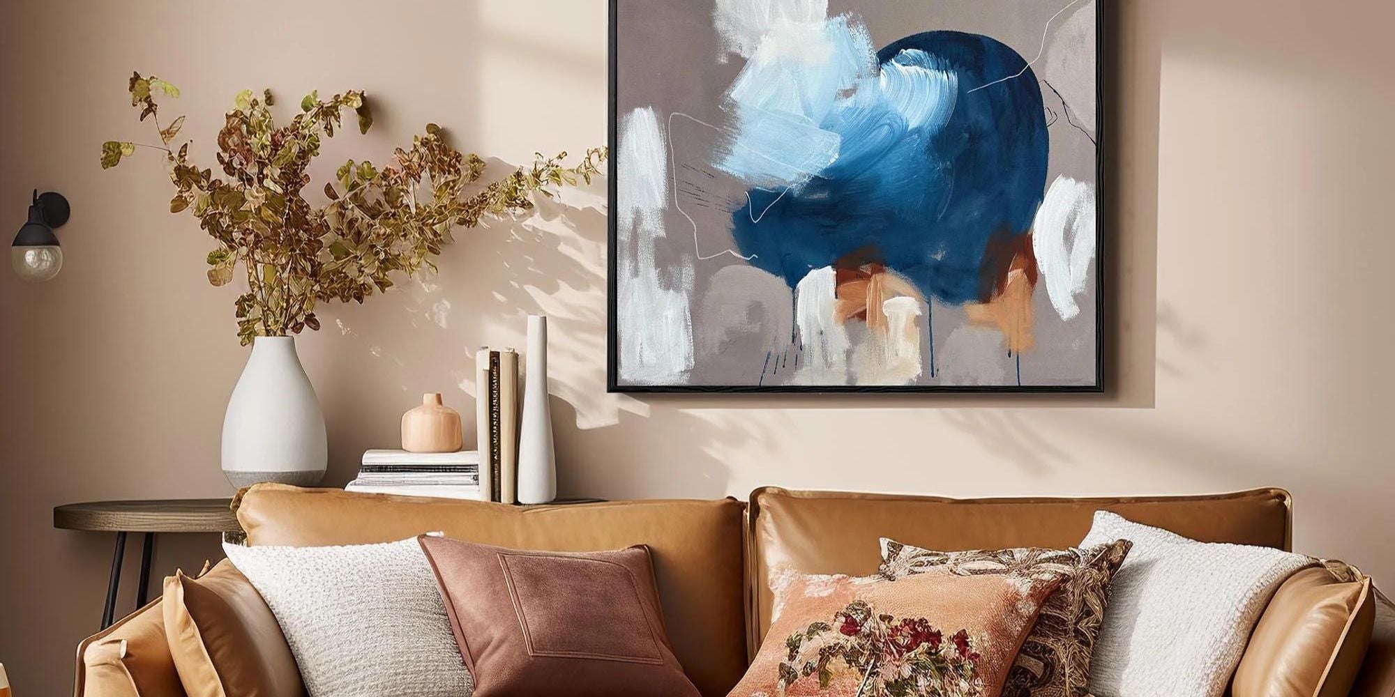 Large abstract painting on wall above sofa in living room
