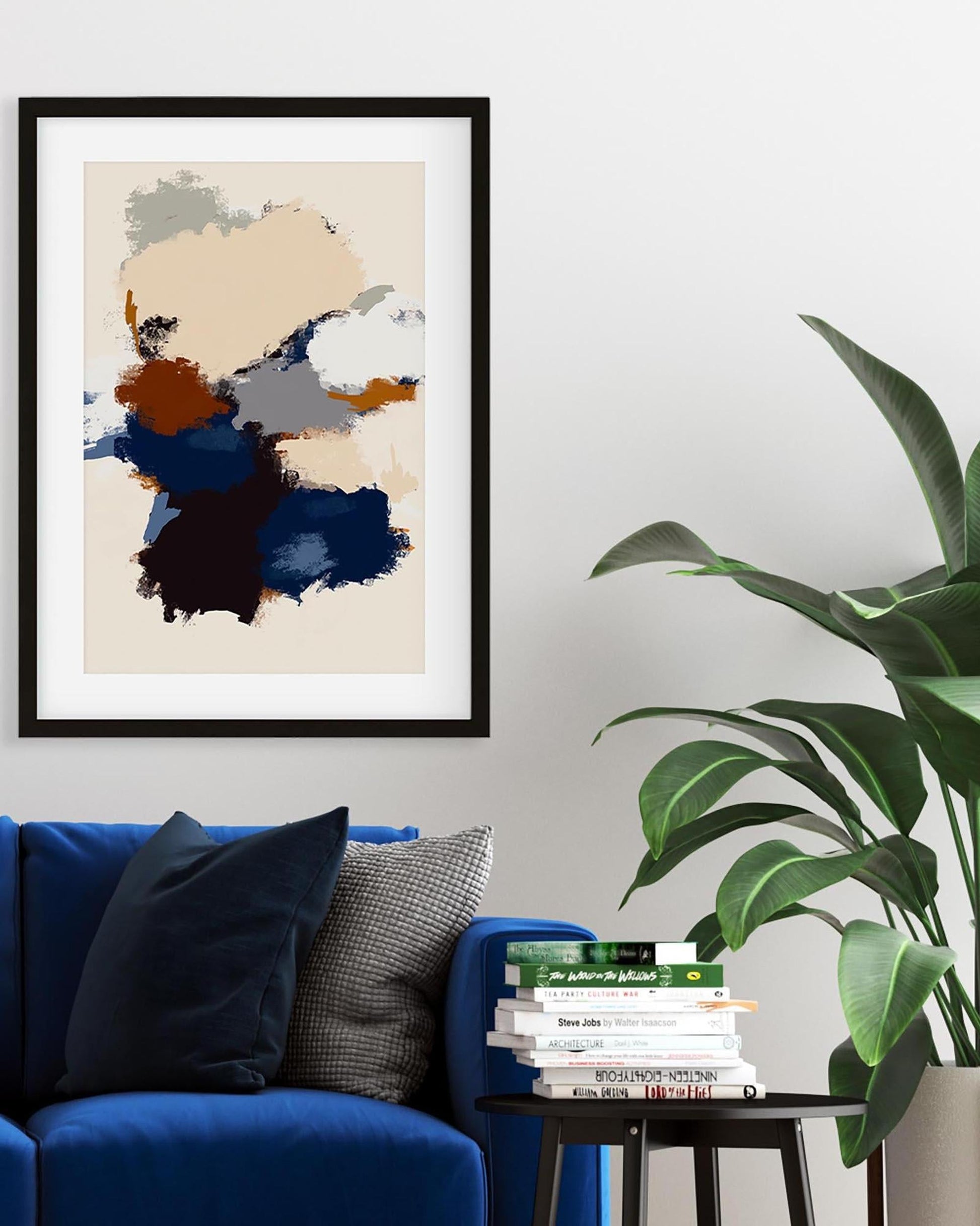 Framed abstract art piece on a wall above a blue sofa with books and a plant.