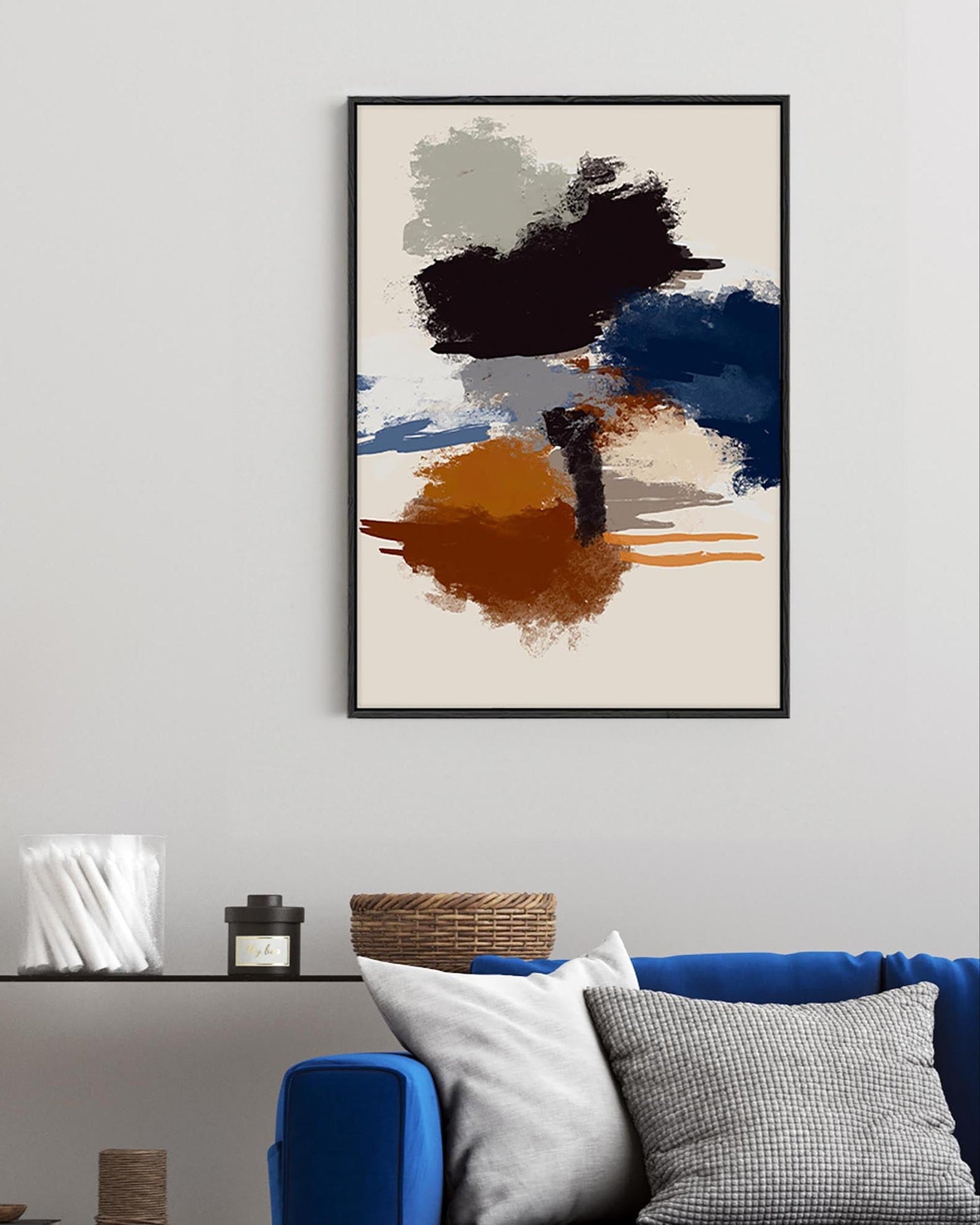 Abstract art print on a wall above a sofa with decorative items.