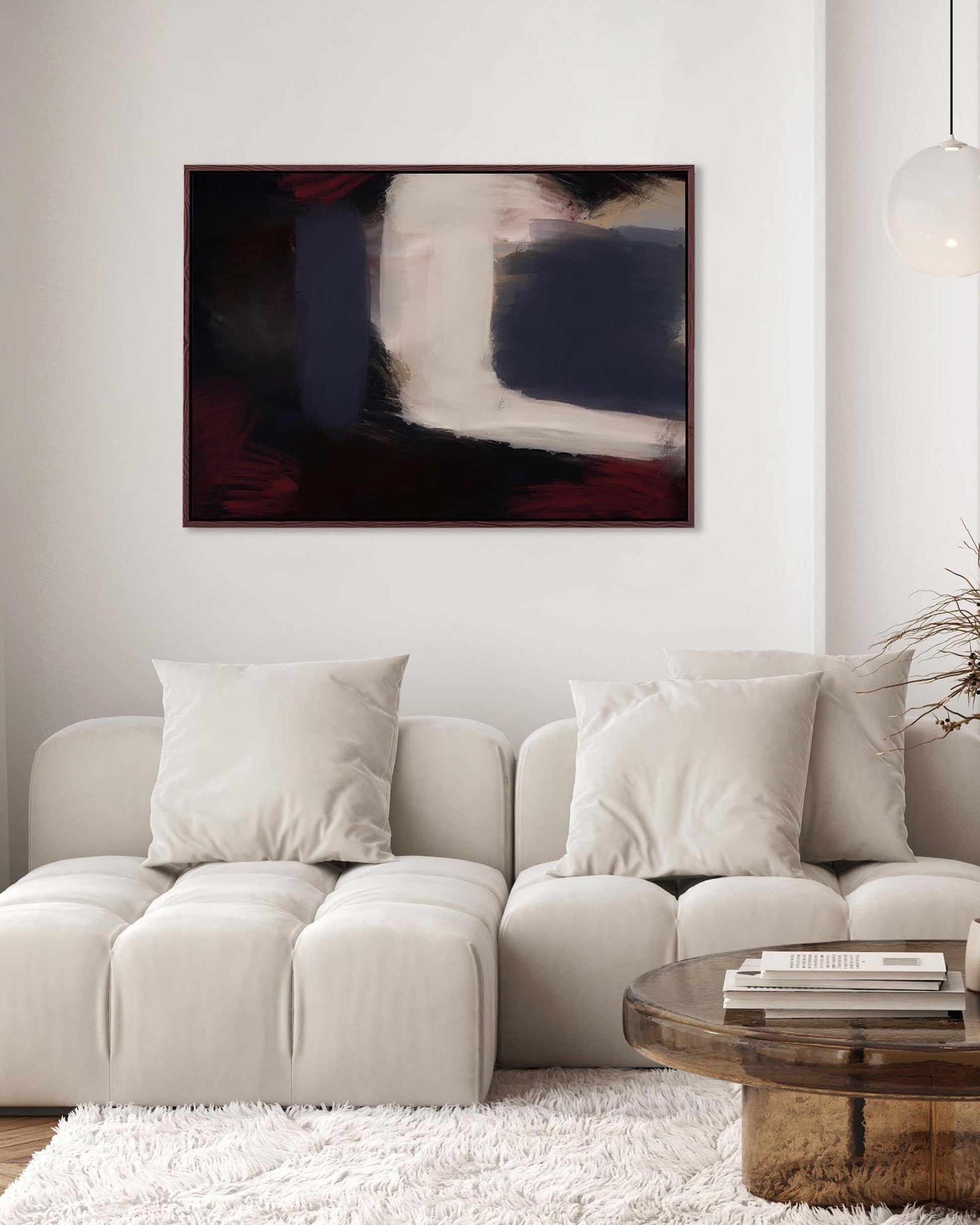 Living room with a beige sofa, abstract painting on the wall, and a wooden coffee table.
