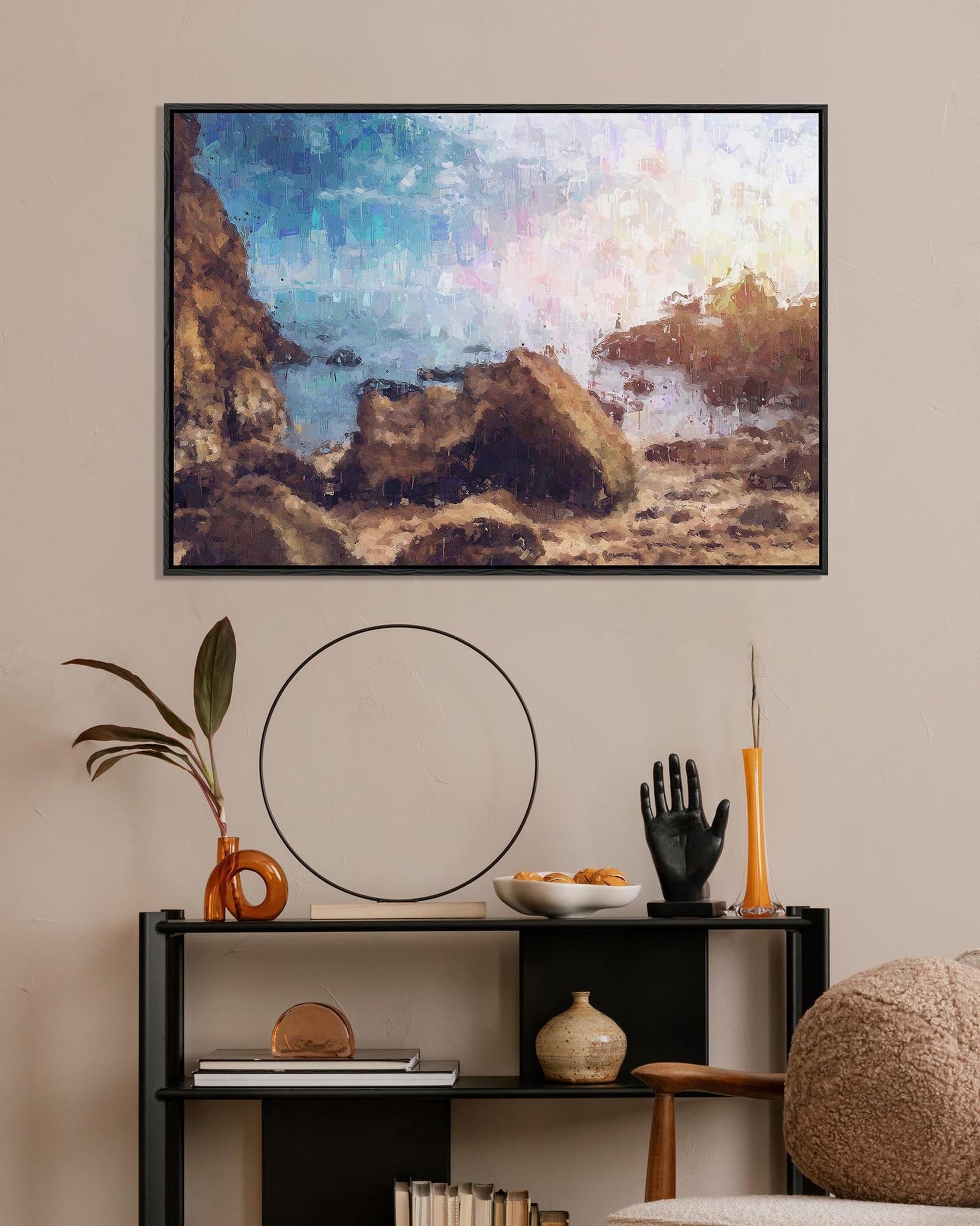 Framed artwork of a coastal scene above a shelf with decorative items.