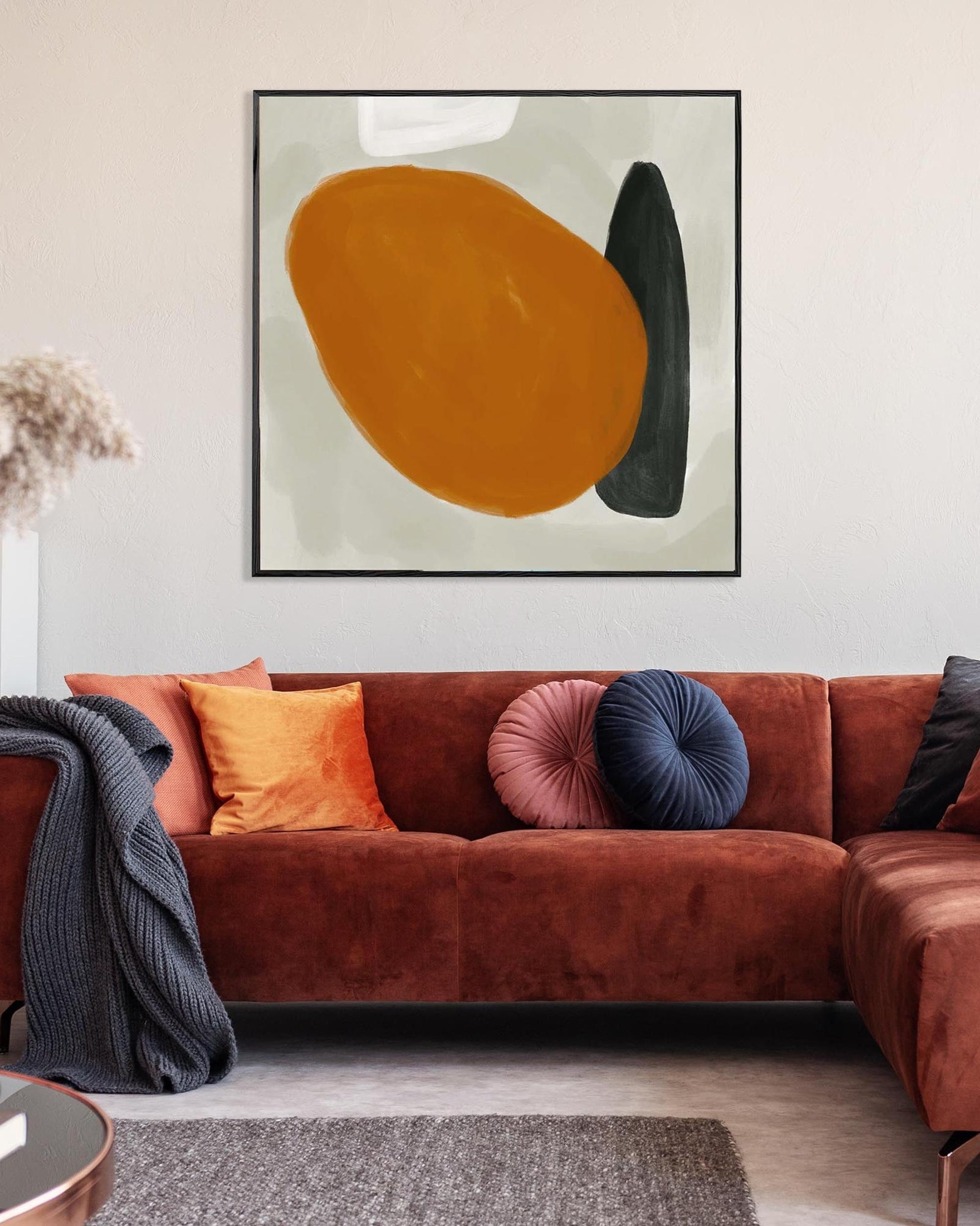 Living room with a brown sectional sofa, colorful cushions, and abstract art on the wall.